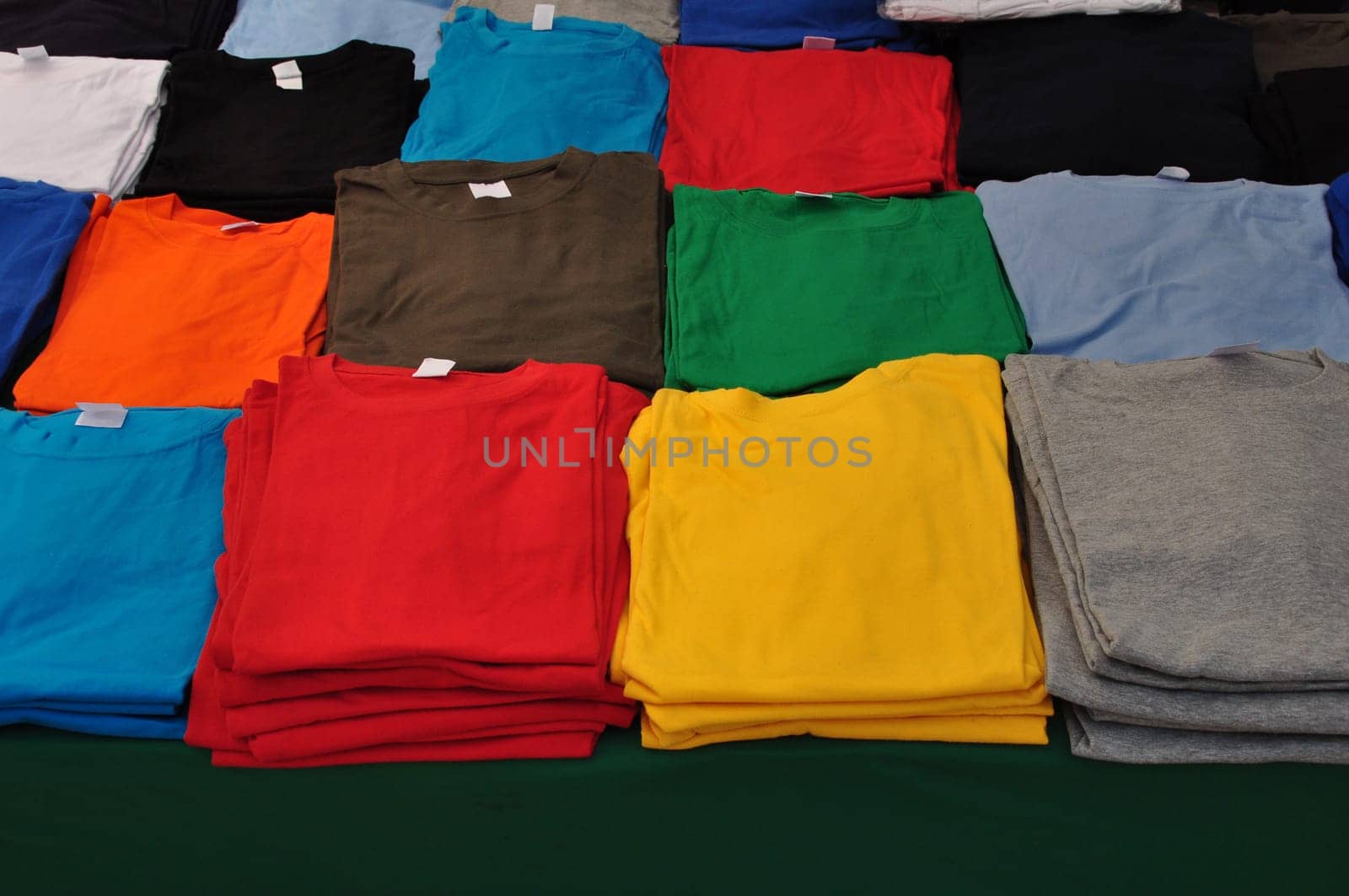 Cotton short sleeve t-shirts folded colorful clothes background.