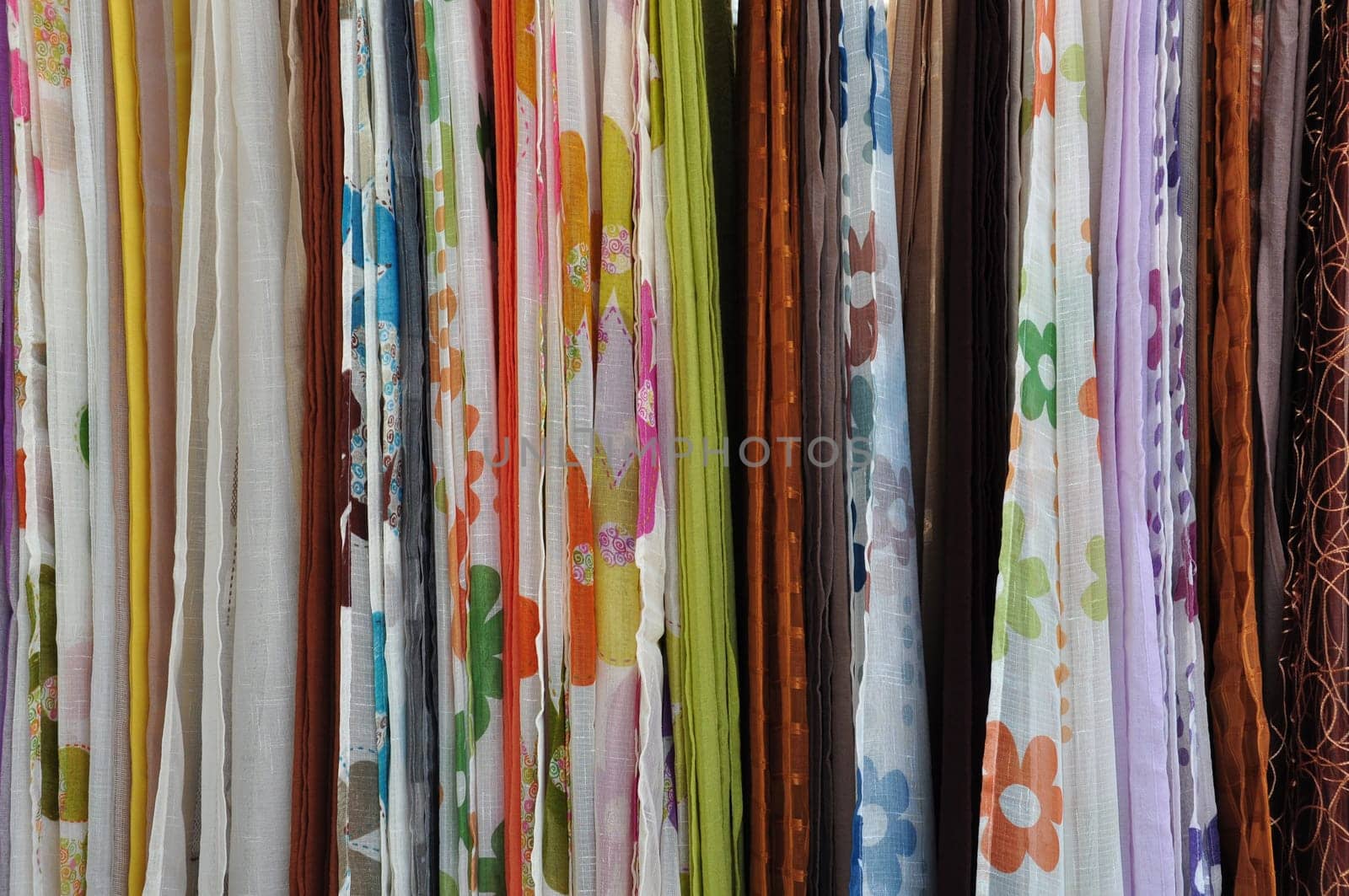 Colorful textiles for sale at street market. Abstract fabric background.