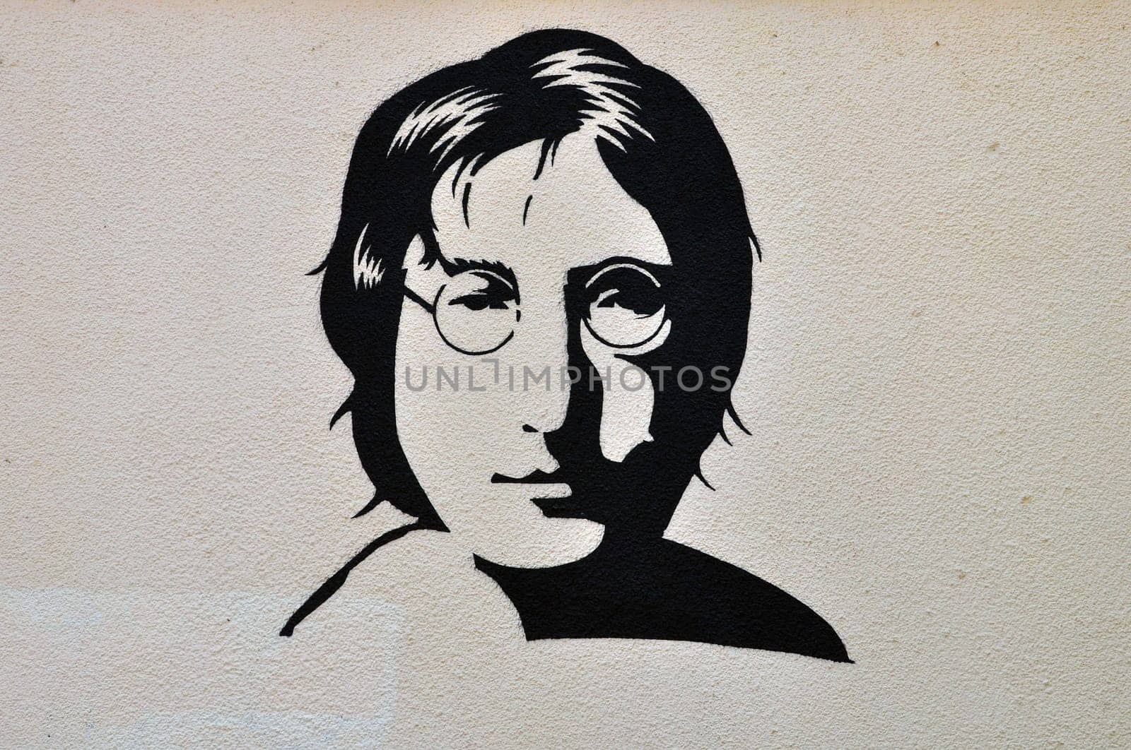 ATHENS, GREECE - AUGUST 30, 2014: John Lennon portrait stencil graffiti urban art on textured wall.