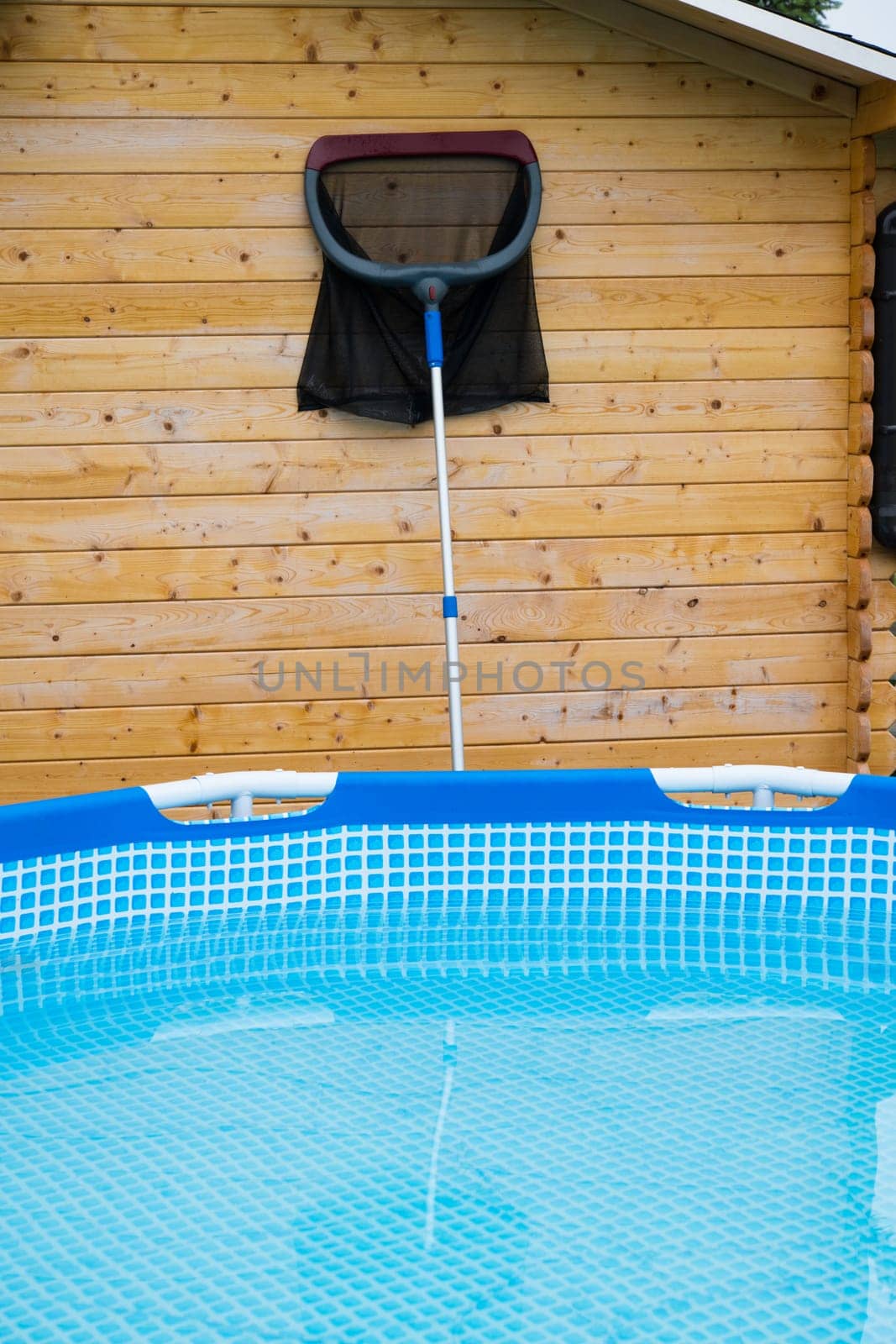 pool with plaid ground and garden shed with cleaning net