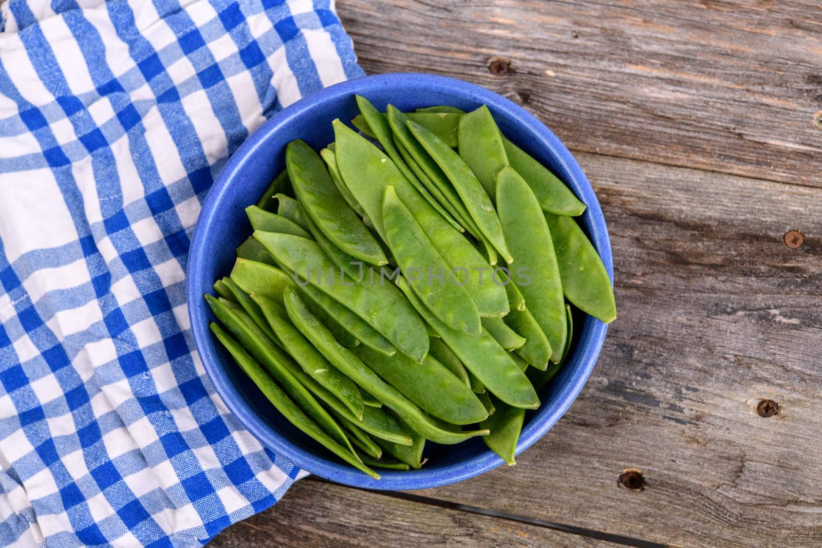 blue bowl with green peapods and towel