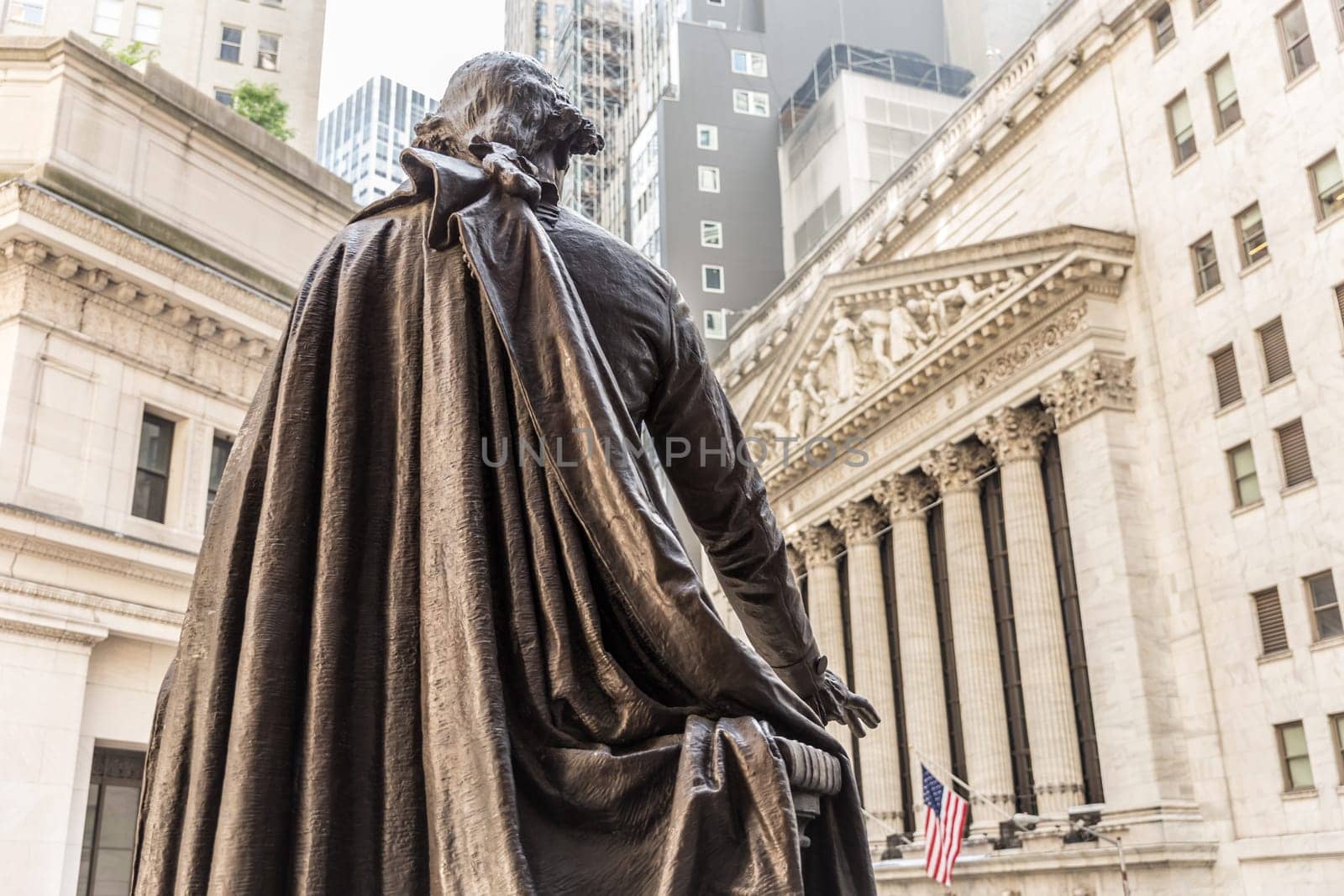 View from Federal Hall of the statue of George Washington and the Stock Exchange building in Wall Street, New York City, USA.