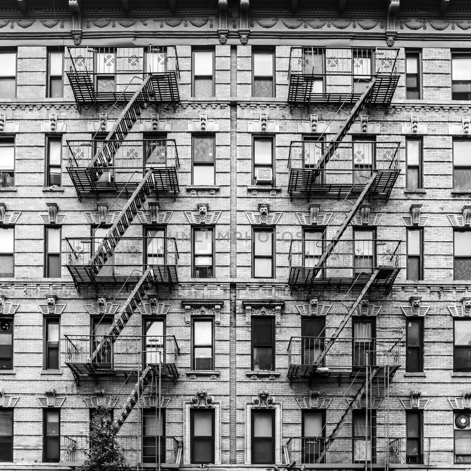 A fire escape of an apartment building in New York city. Graphical black and white image.