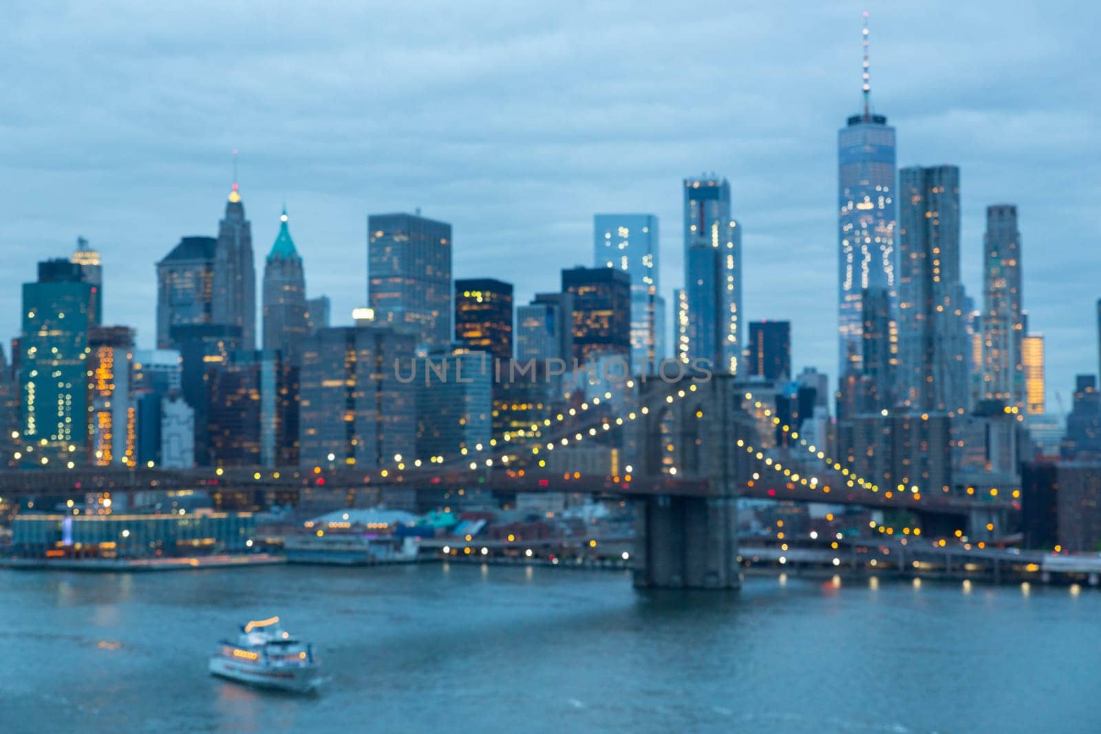 Out of focus image of Brooklyn Bridge and Lower Manhattan skyline at night seen from Manhattan bridge, New York city, USA.