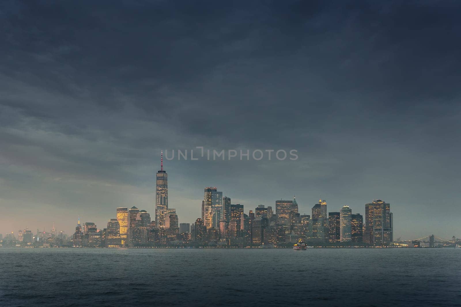 Dramatic panoramic view of storm over Lower Manhattan from Ellis Island at dusk, New York City.