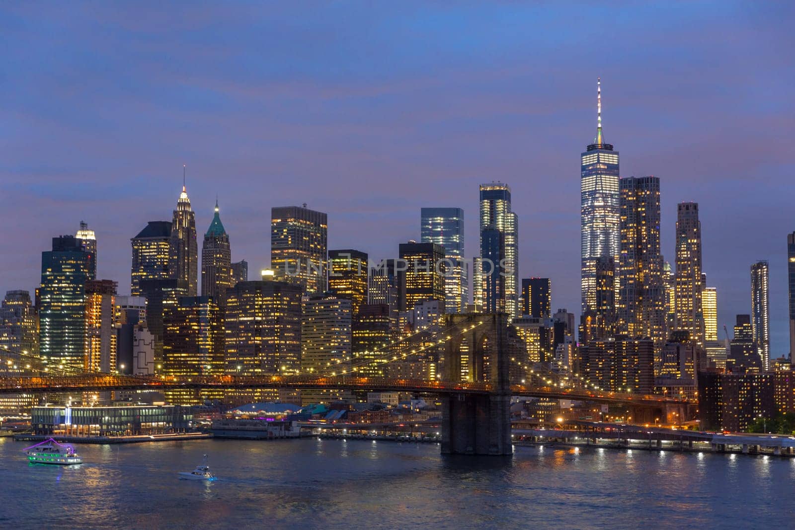 Brooklyn park, Brooklyn Bridge, Janes Carousel and Lower Manhattan skyline at night seen from Manhattan bridge, New York city, USA.
