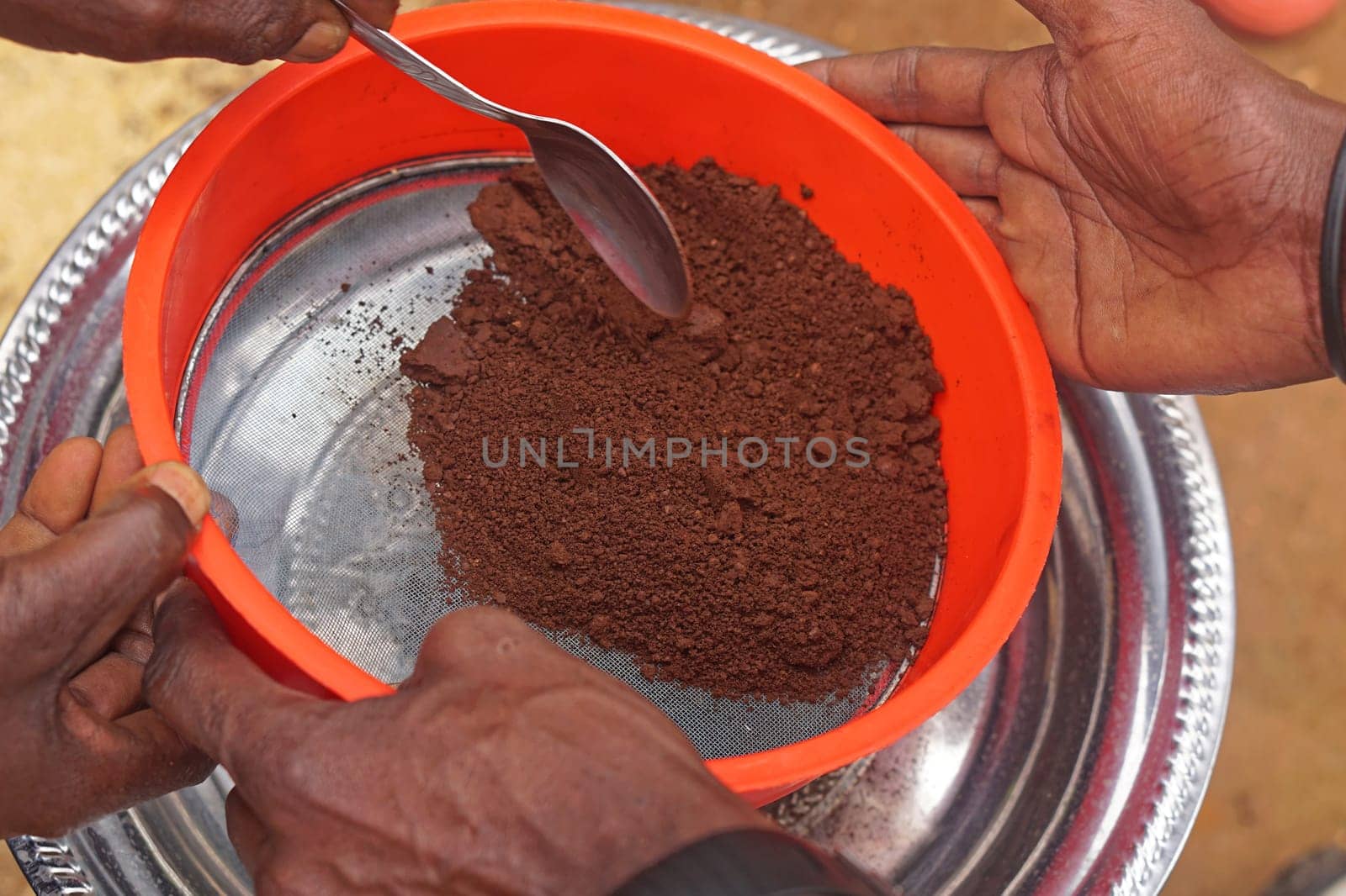 Sifting grinded coffee powder in tray