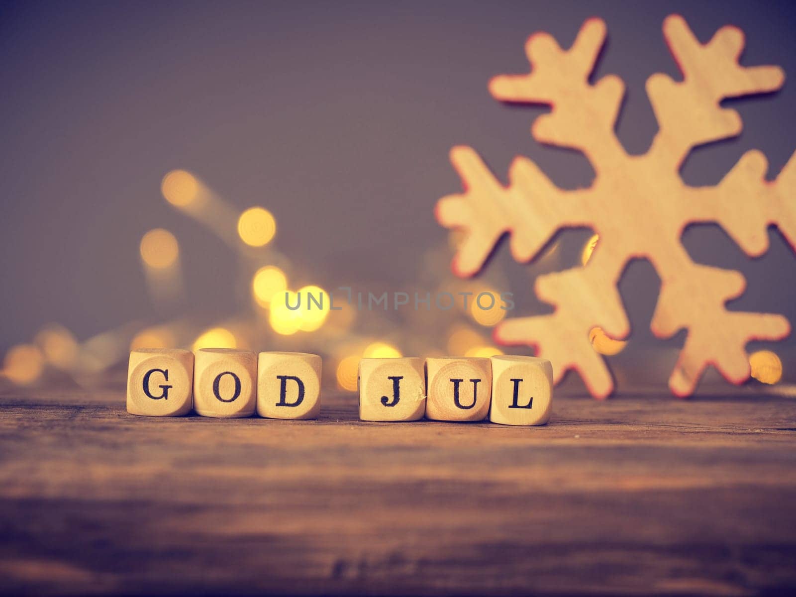God Jul, Scandinavian Merry Christmas on wooden dices with blurred lights and decoration
