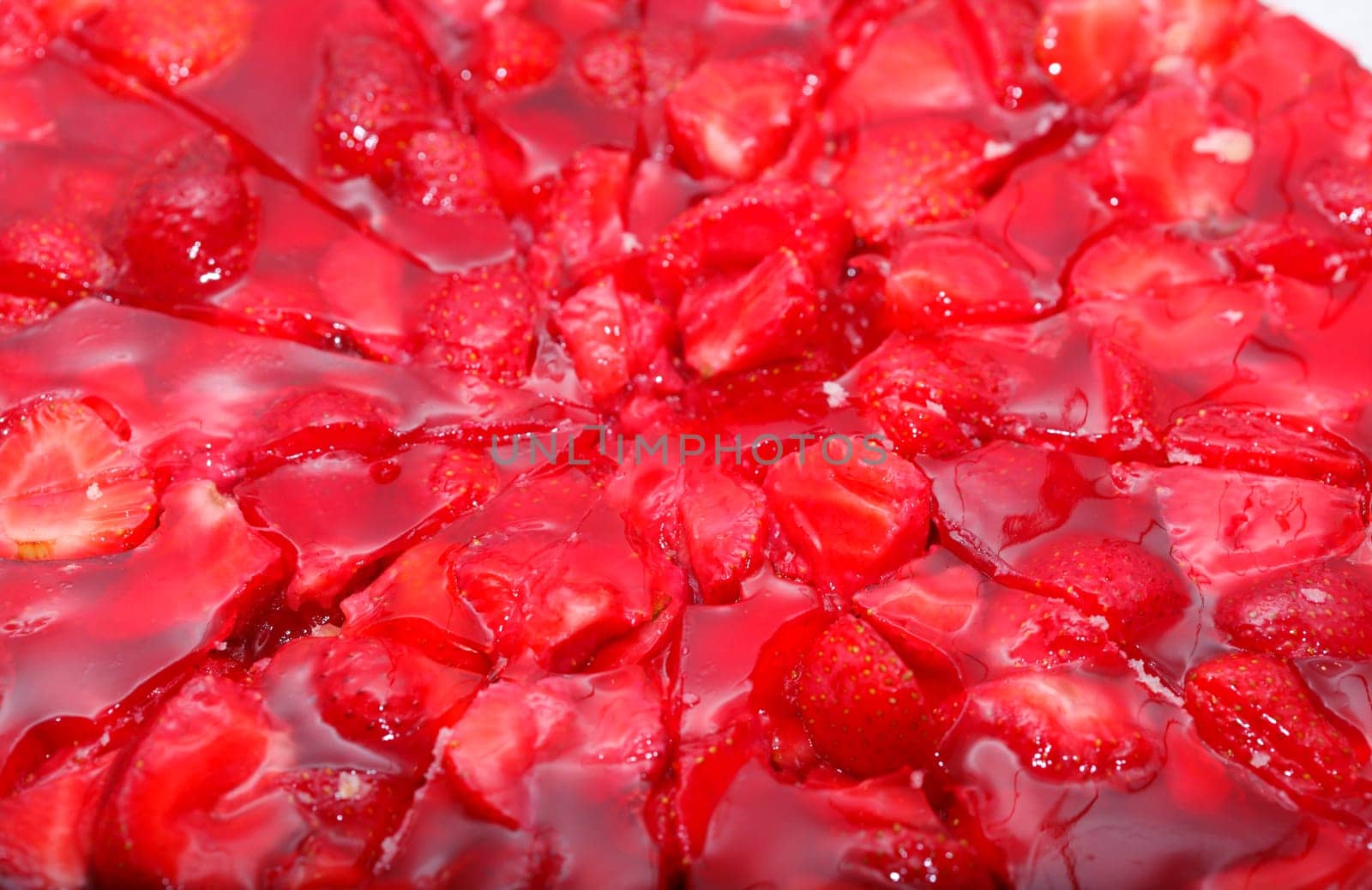 Glsed red strawberries on a strawberry cake,background