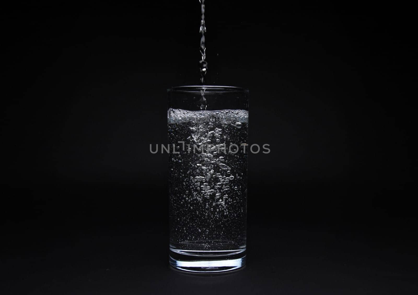 Full glass of water isolated on black background