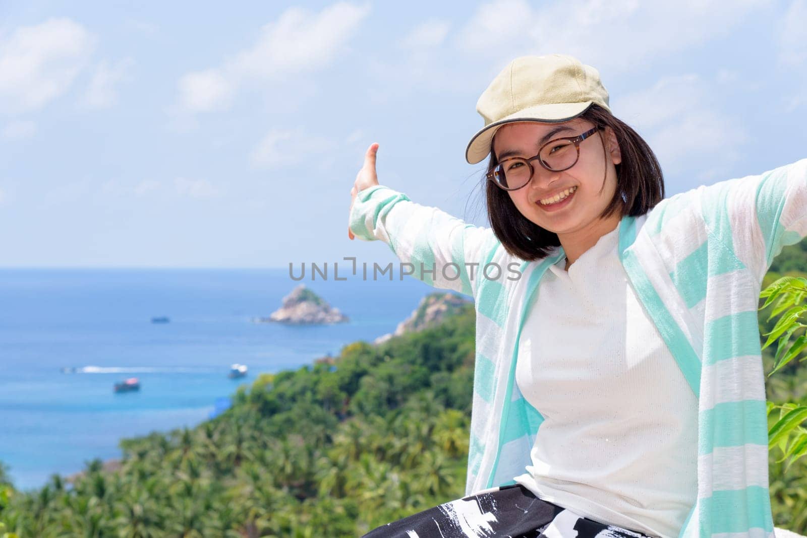 Women tourists extend the arms happily at high viewpoint to see the beautiful nature landscape of the sea and island on top of the Koh Tao island is a famous attractions in Surat Thani, Thailand