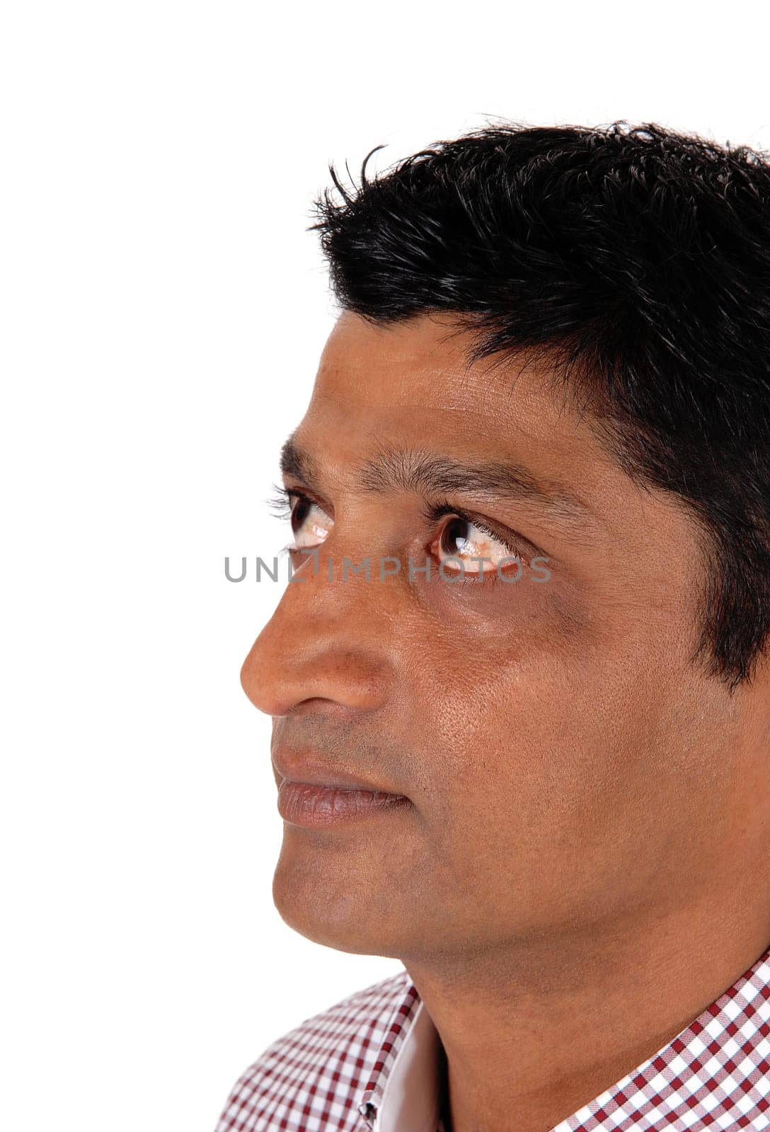 The face of an East Indian man in closeup looking up with his darker.skin color, isolated for white background.