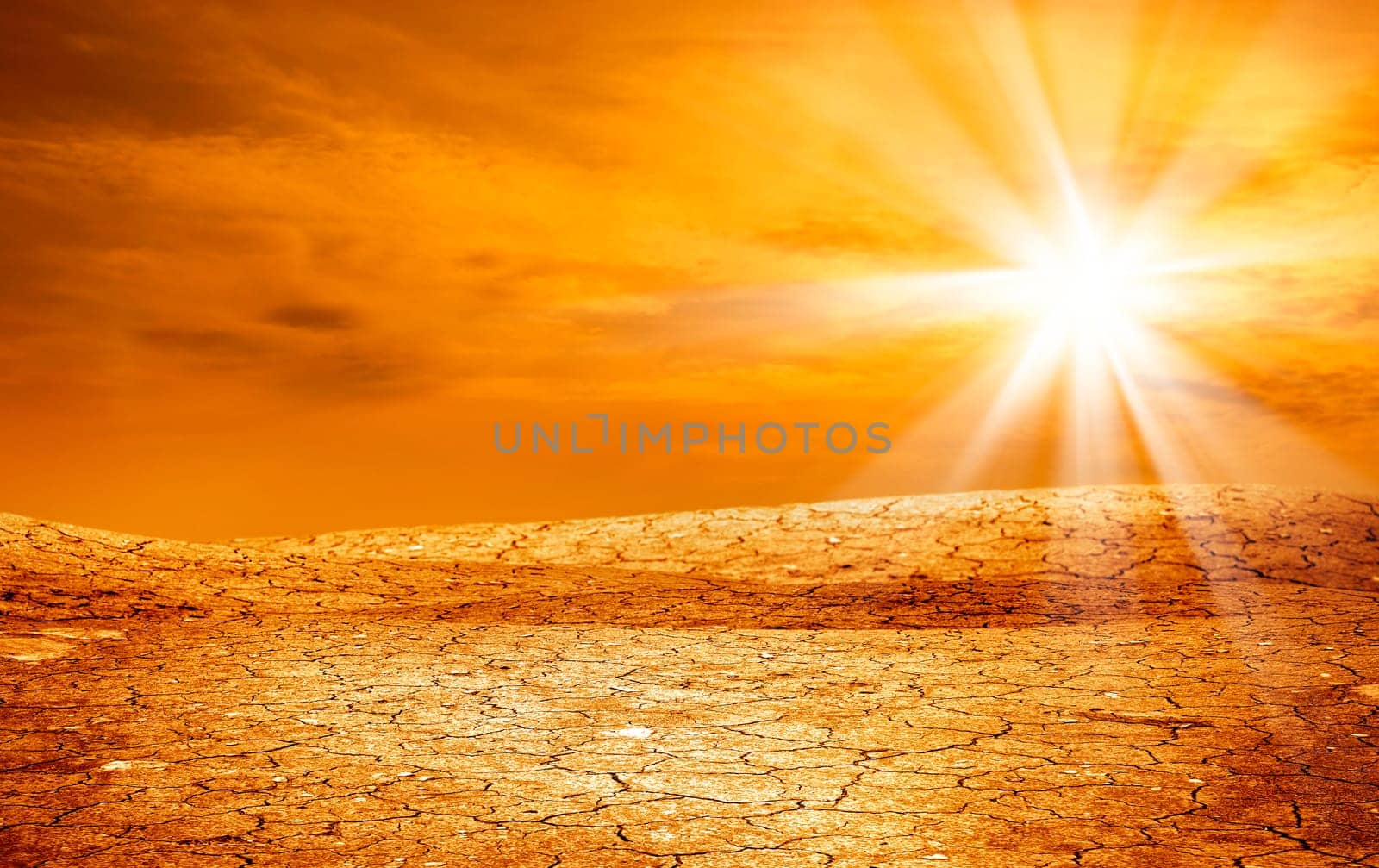 conceptual image of dried and cracked landscape over sunset.