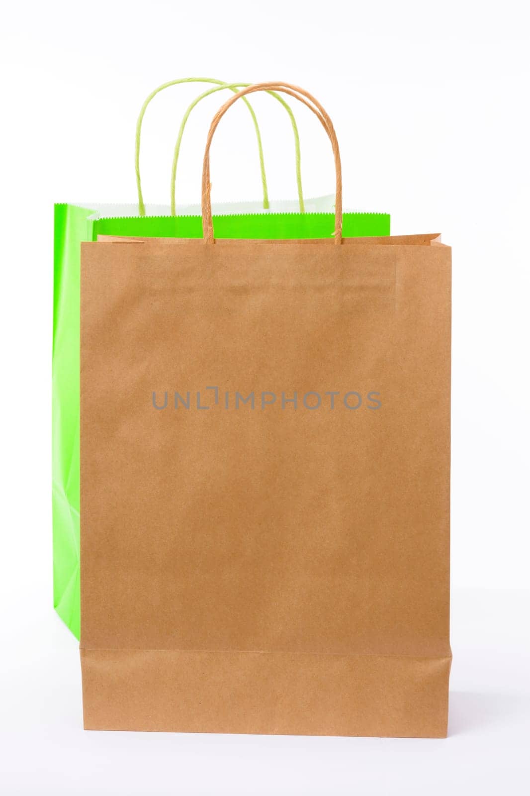 Variety of colored paper shopping bags on white background. Empty area.