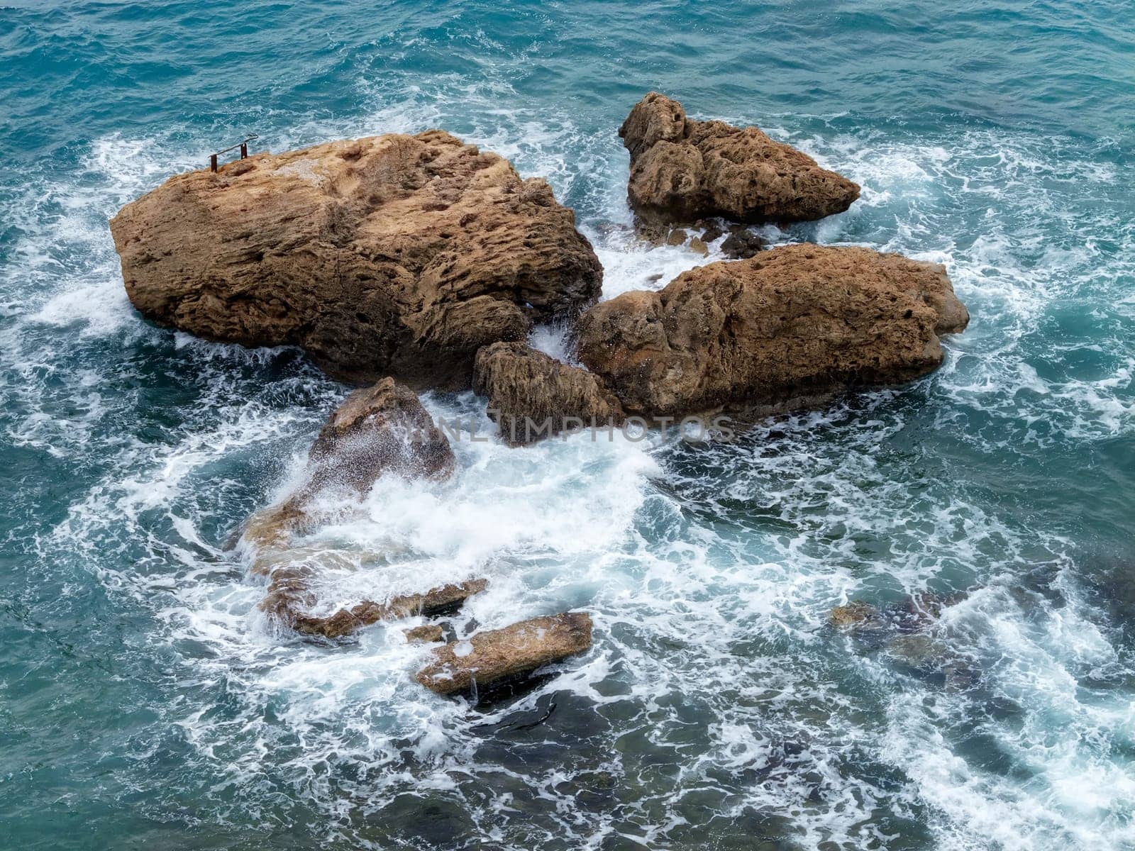 elevated view of rocks in blue water sea and waves in Antalya, Turkey