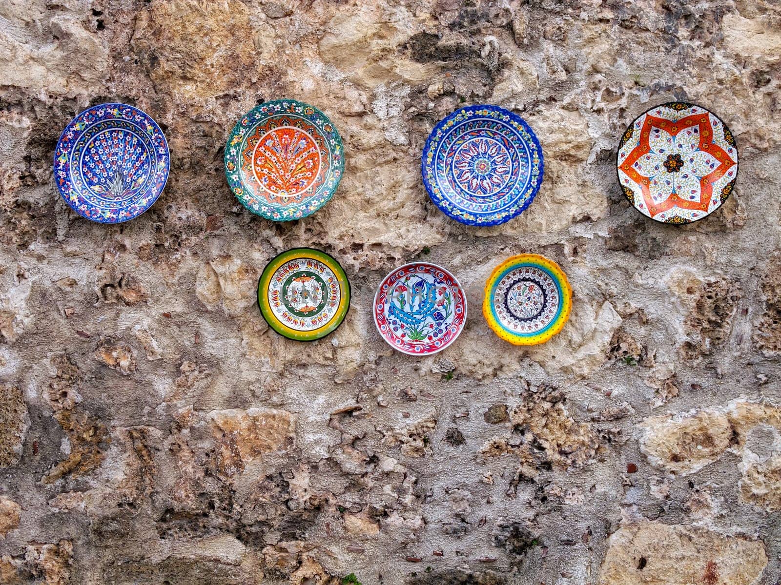 close up handmade ceramic plates hanged on wall
