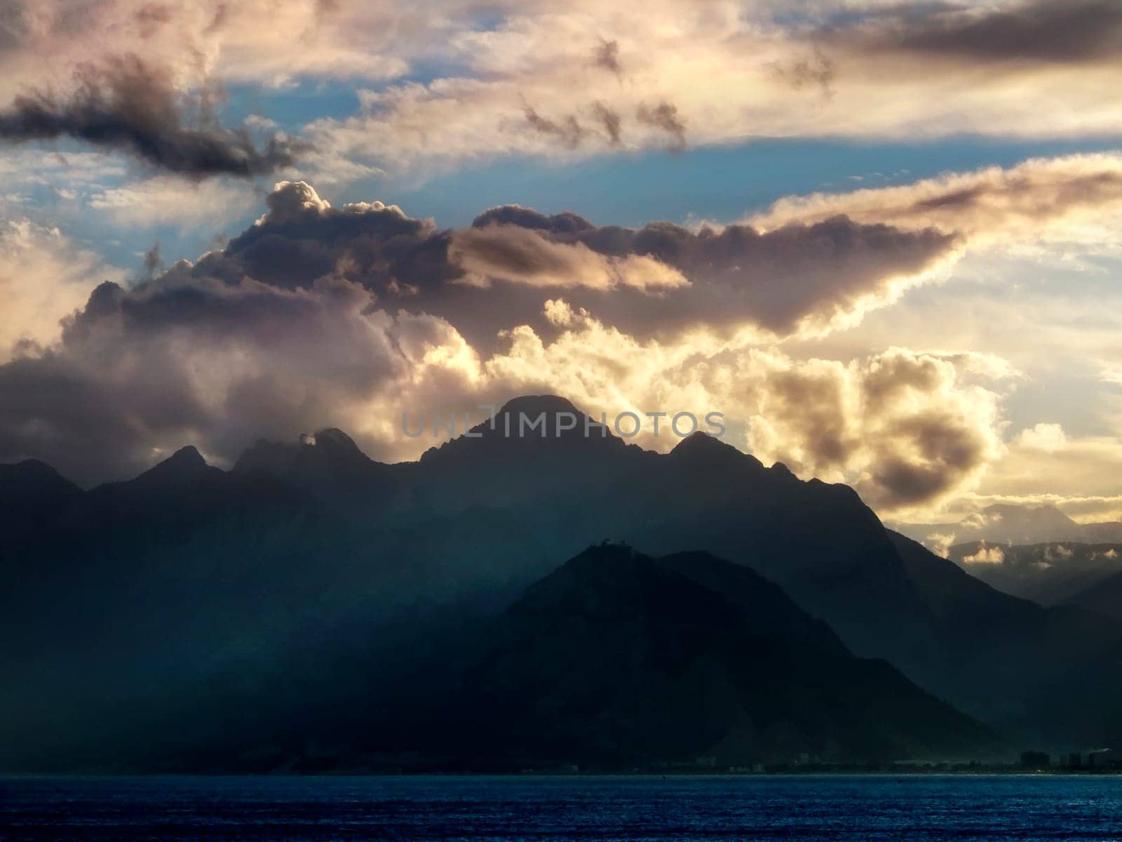 landscape image of high mountains over cloudy sunset sky in Antalya, Turkey.