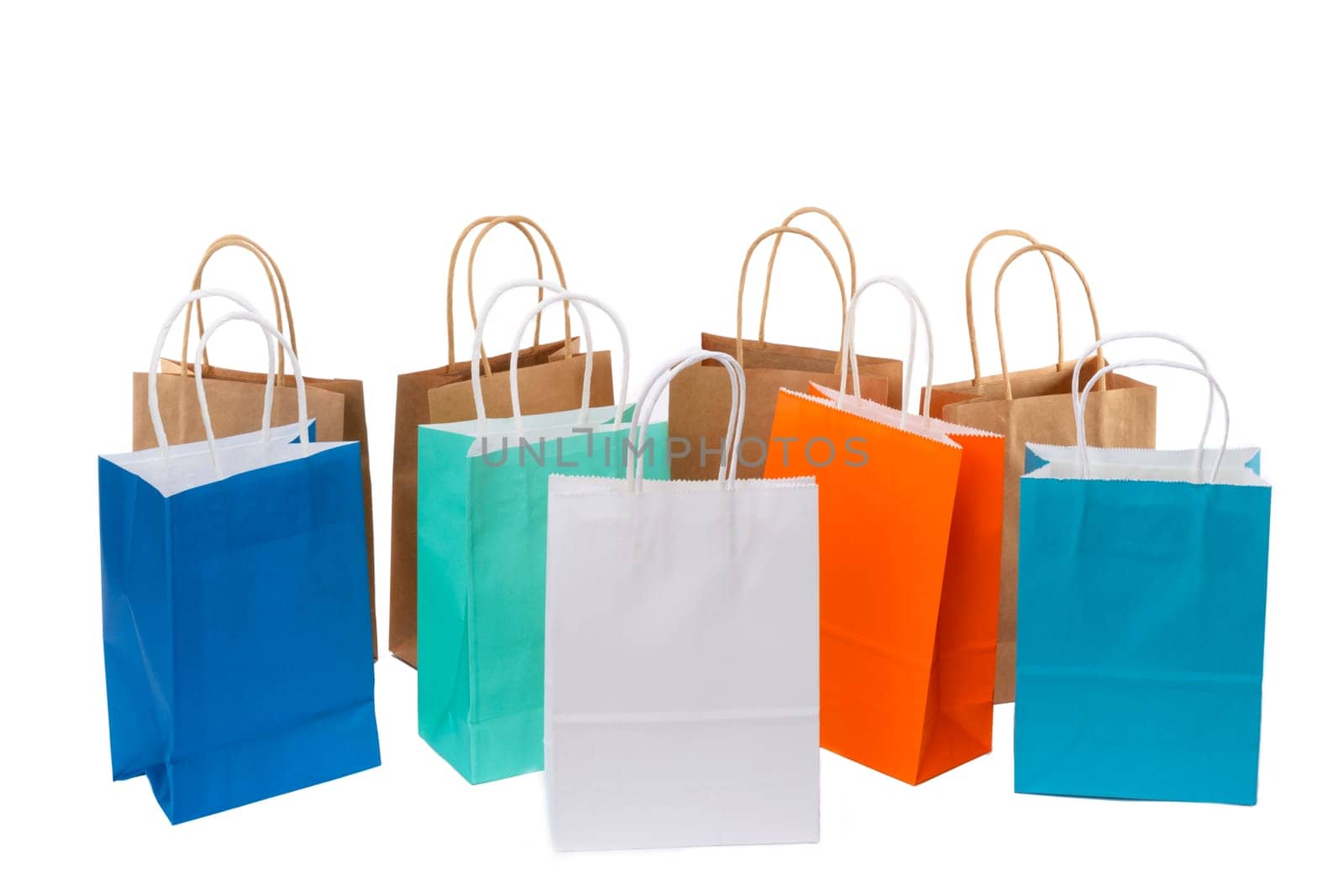 Variety of colored paper shopping bags on white background. Empty area.