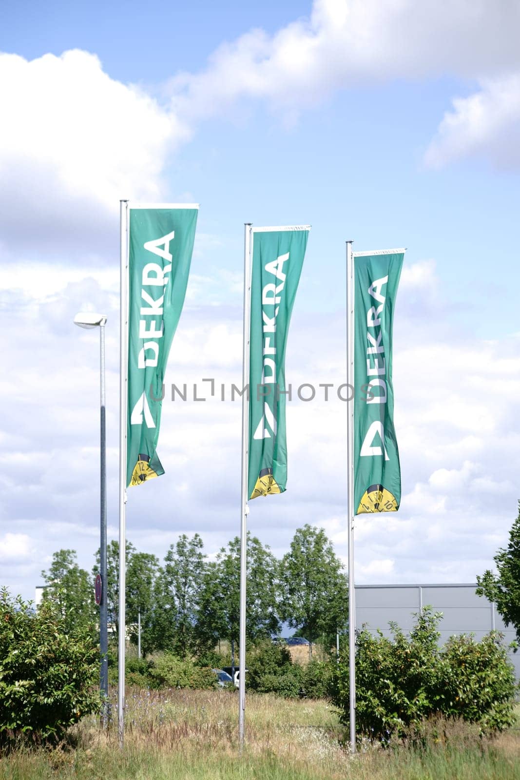 Mainz,Germany - June 18,2018: Waving flags of the vehicle inspection center Dekra with logo in the wind on June 18,2018 in Mainz.