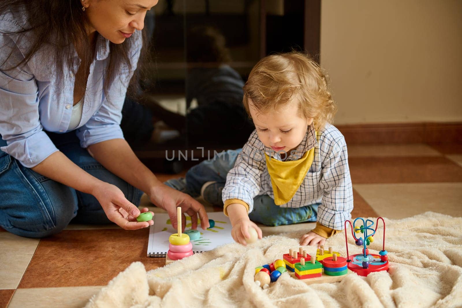 A mother and her toddler spend quality time together indoors, engaged in educational and playful activities that nurture the child's development and strengthen their emotional bond.