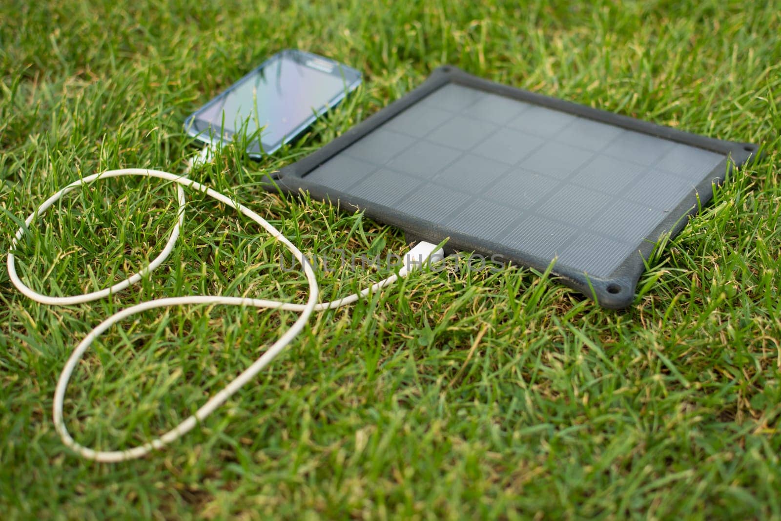 Use of renewable energy - Mobile Phone Chargers on grass in nature with Sun