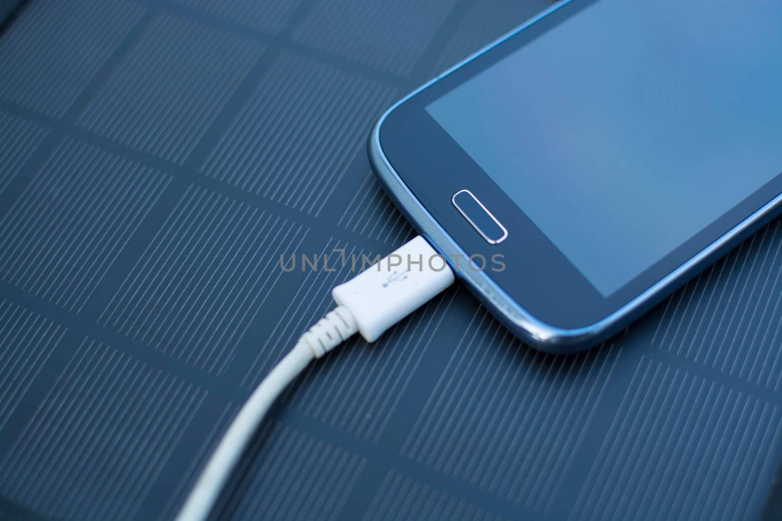 Use of renewable energy - Mobile Phone Chargers on grass in nature with Sun