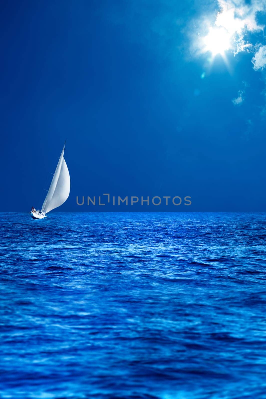 seascape image of sailing boat on sea over sunny sky.