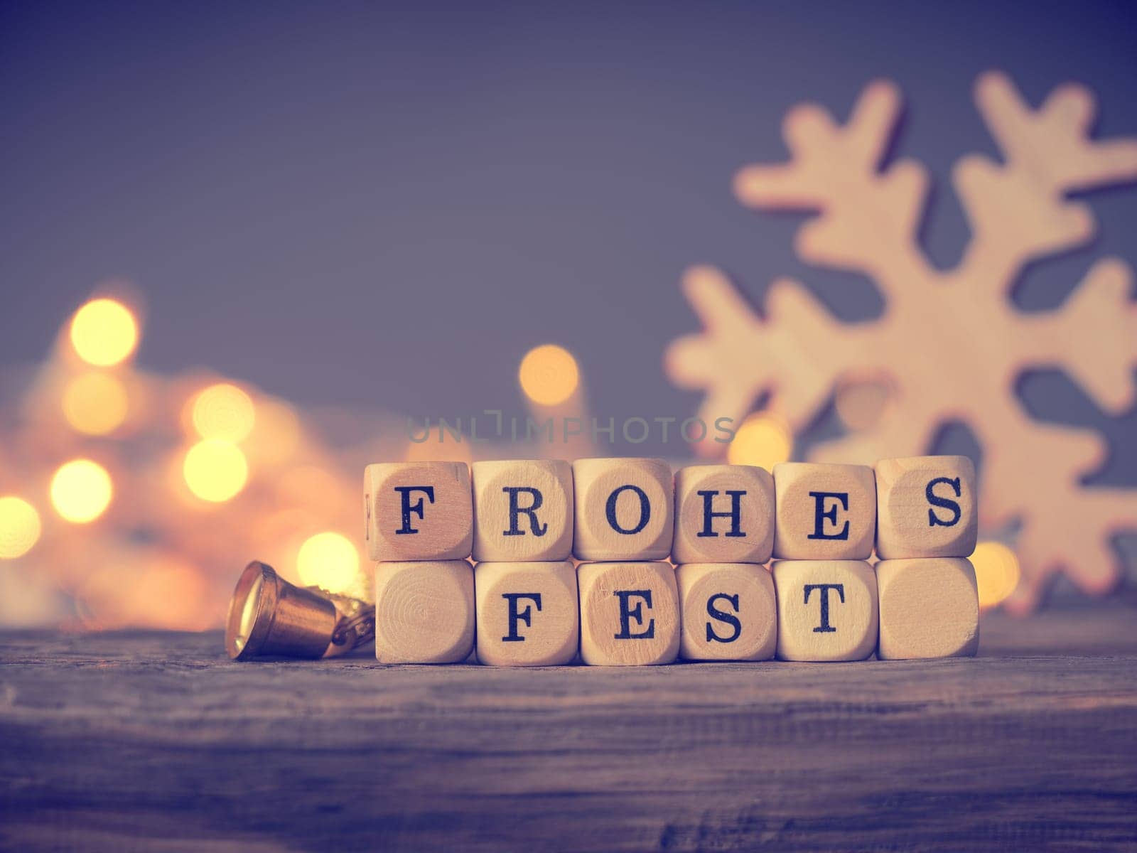 German Merry Christmas on wooden dices with blurred lights and decoration