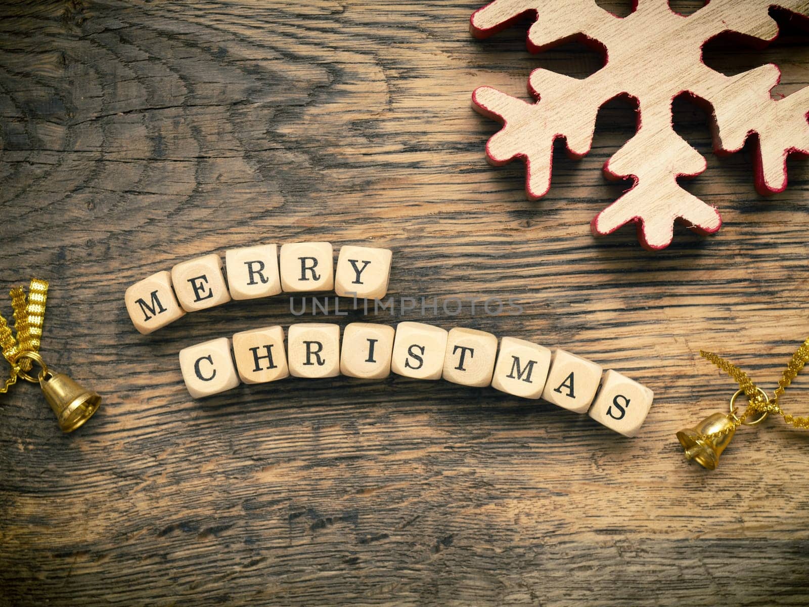 Merry Christmas on small wooden dices with Christmas decoration on a wooden board