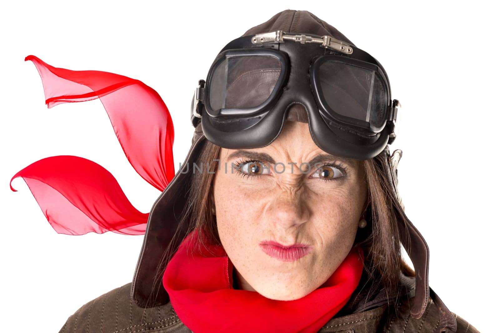 Funny girl with freckles wearing helmet, goggles and a red scarf