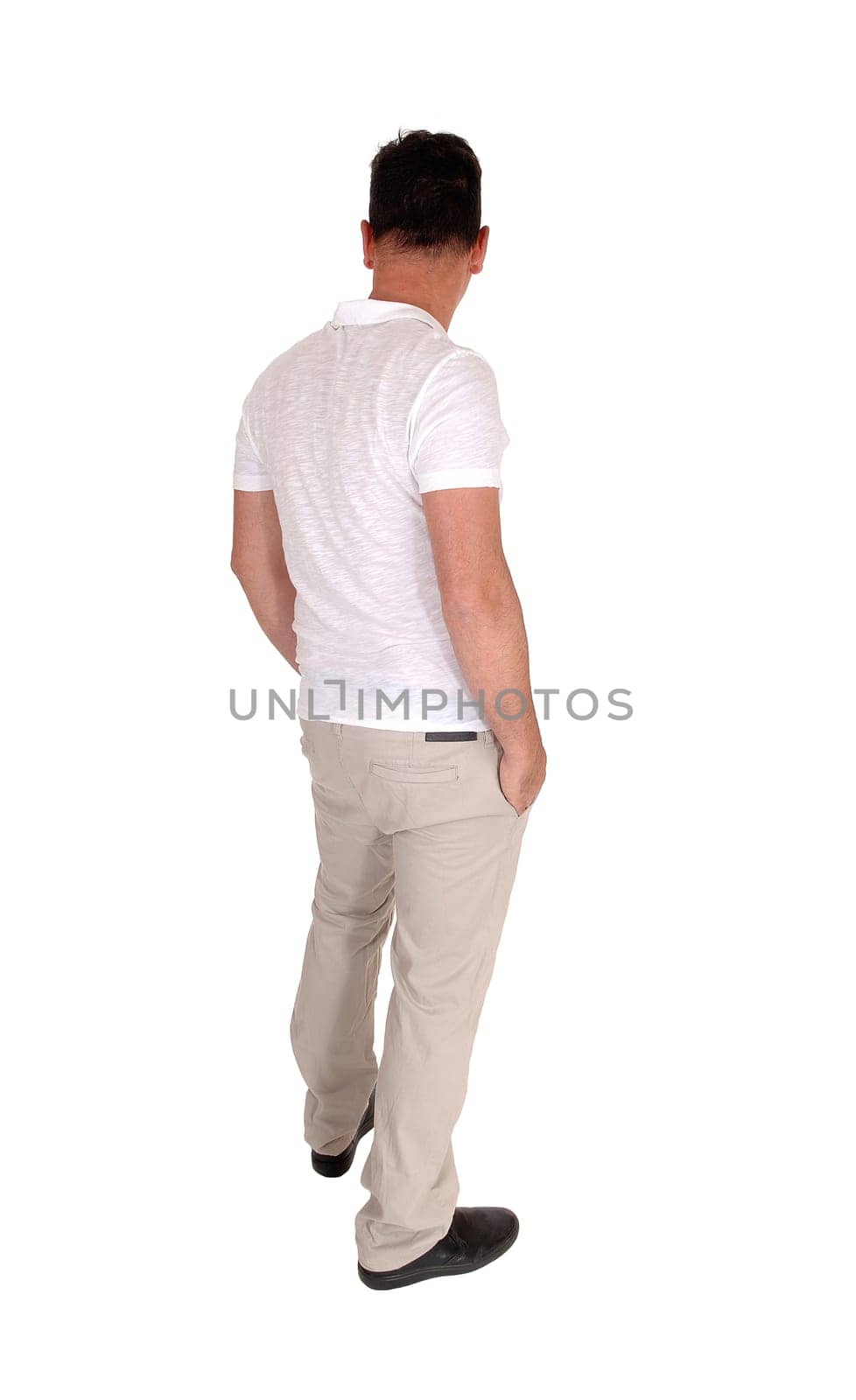 A tall handsome middle age man standing in a beige slacks and white t-shirt .with his hands in his pocket, from the back, isolated for white background.