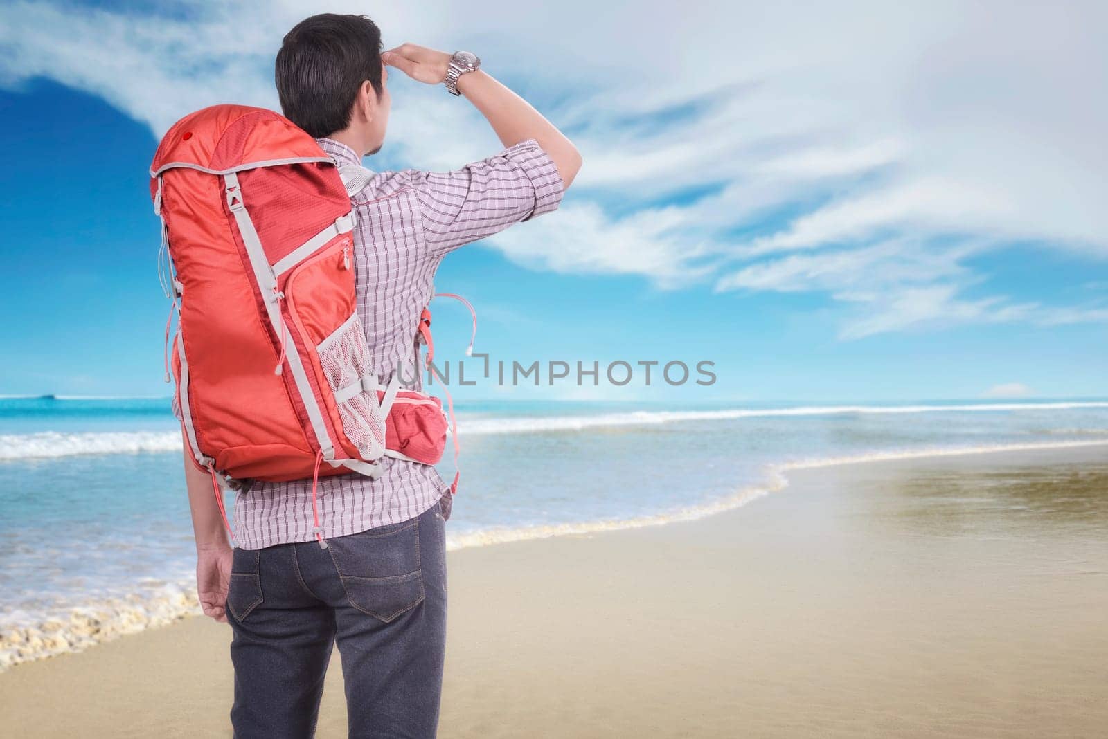 Rear view of asian traveler man looking at view on the beach