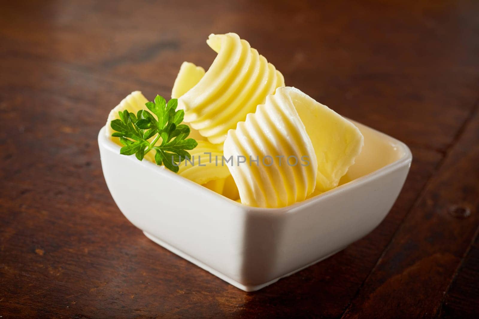 one bowl of nice butter curls on a wooden brown table. Delicious organic local food for breakfast.