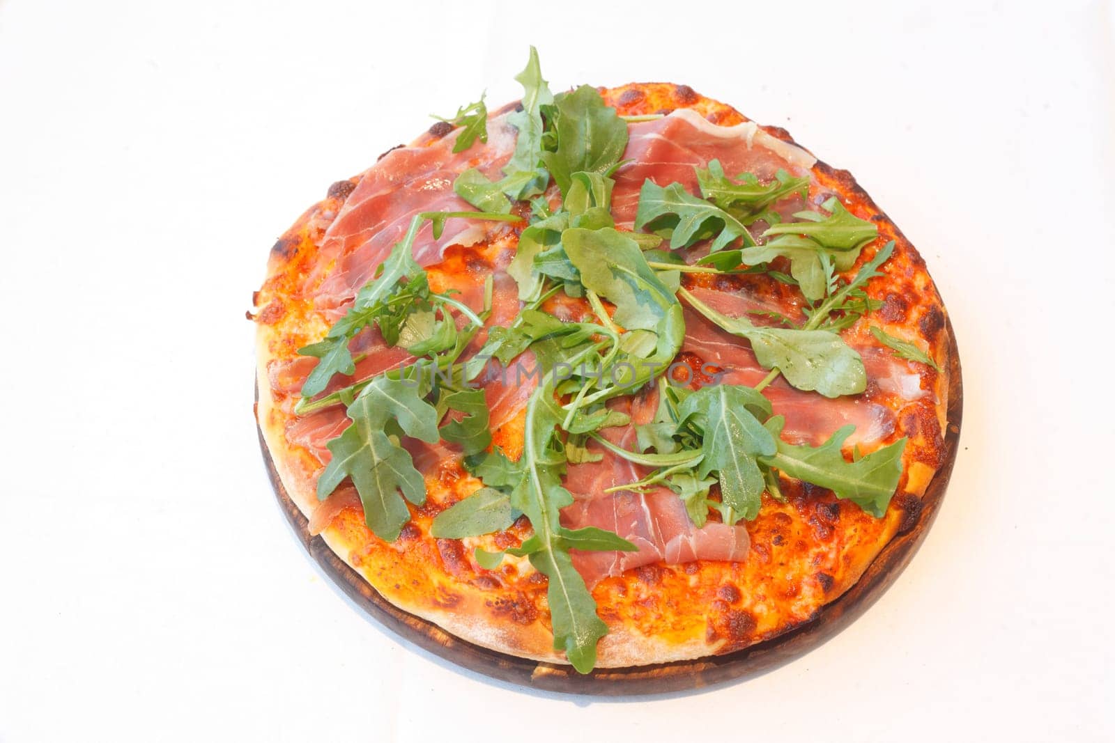 Pizza with rocket,Parma ham and cheese,on a wooden board,wise background