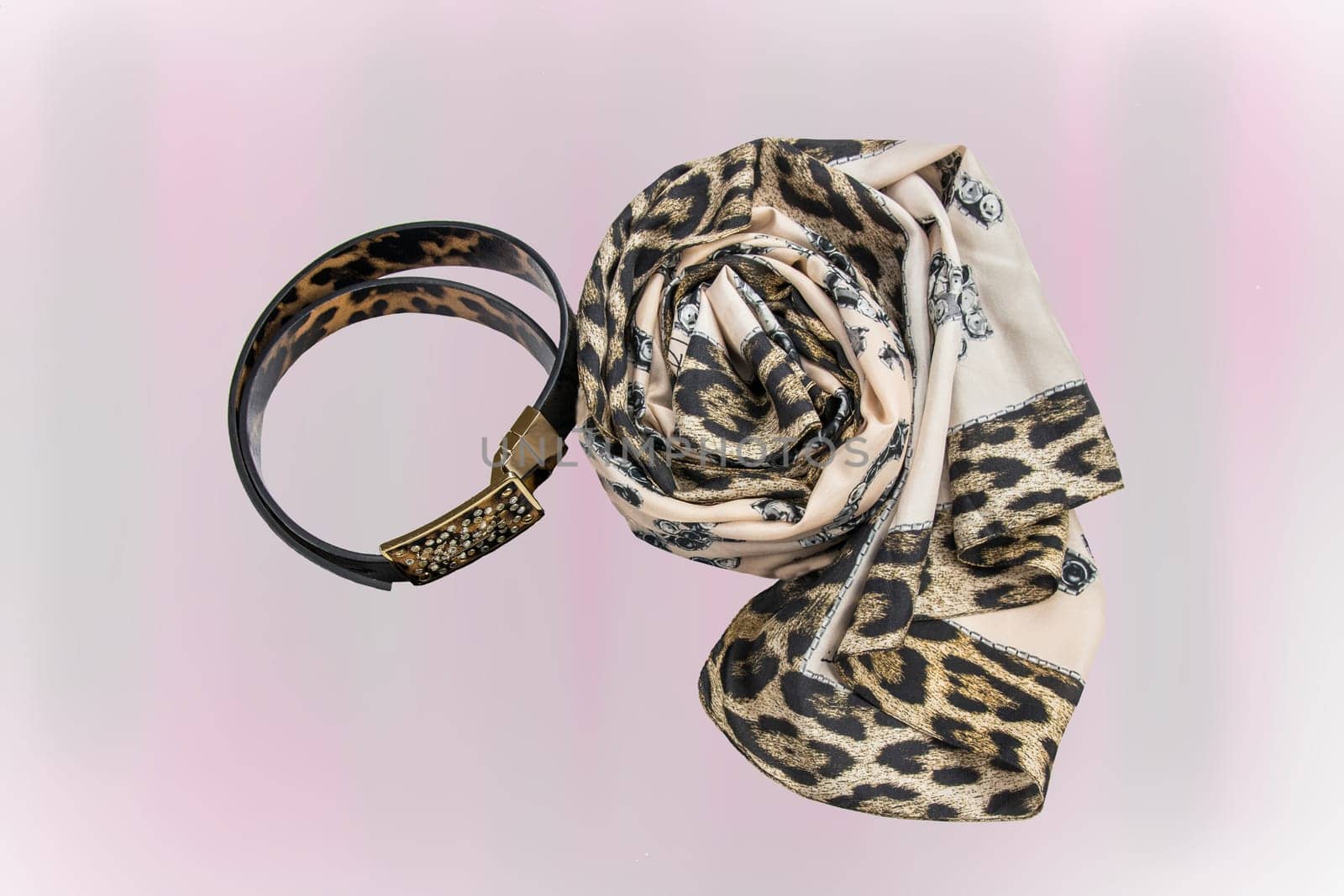 Womans fashions accessories. A luxurious beautiful leather belt and a matching scarf in front of bright purple background. Beautiful texture. Space..