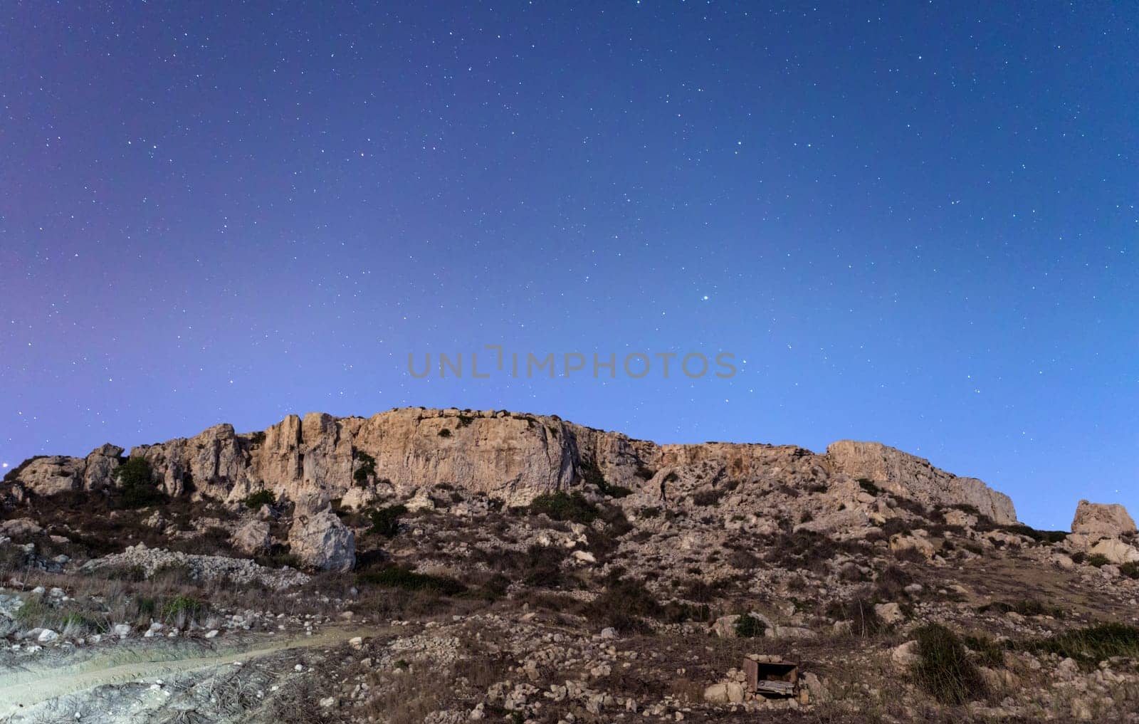 The cliffs at Mgiebah Bay in Malta, under a starry sky.
