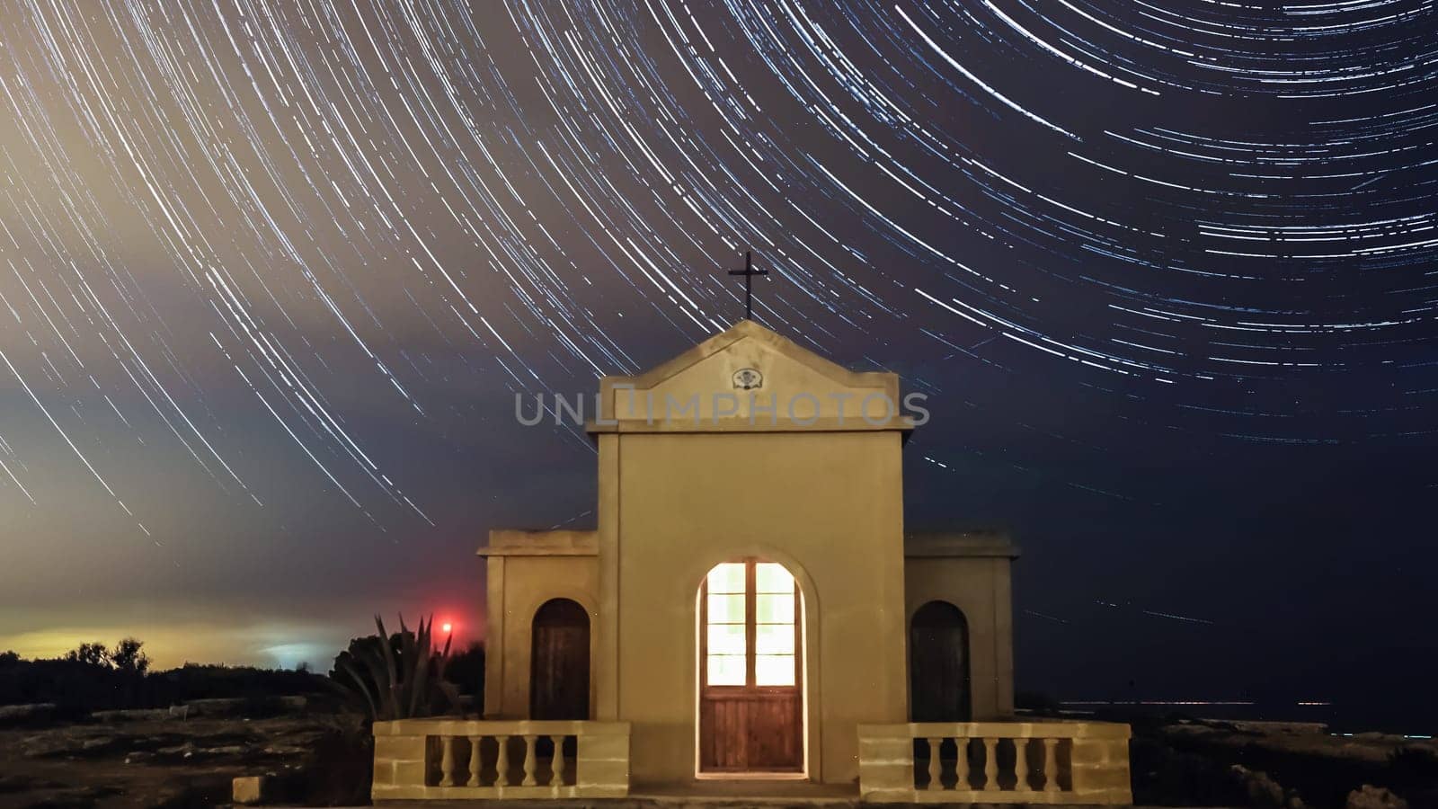 Extreme long exposure image showing star trails around the Polar Star or Polaris in sky over chapal in Ahrax Point Malta