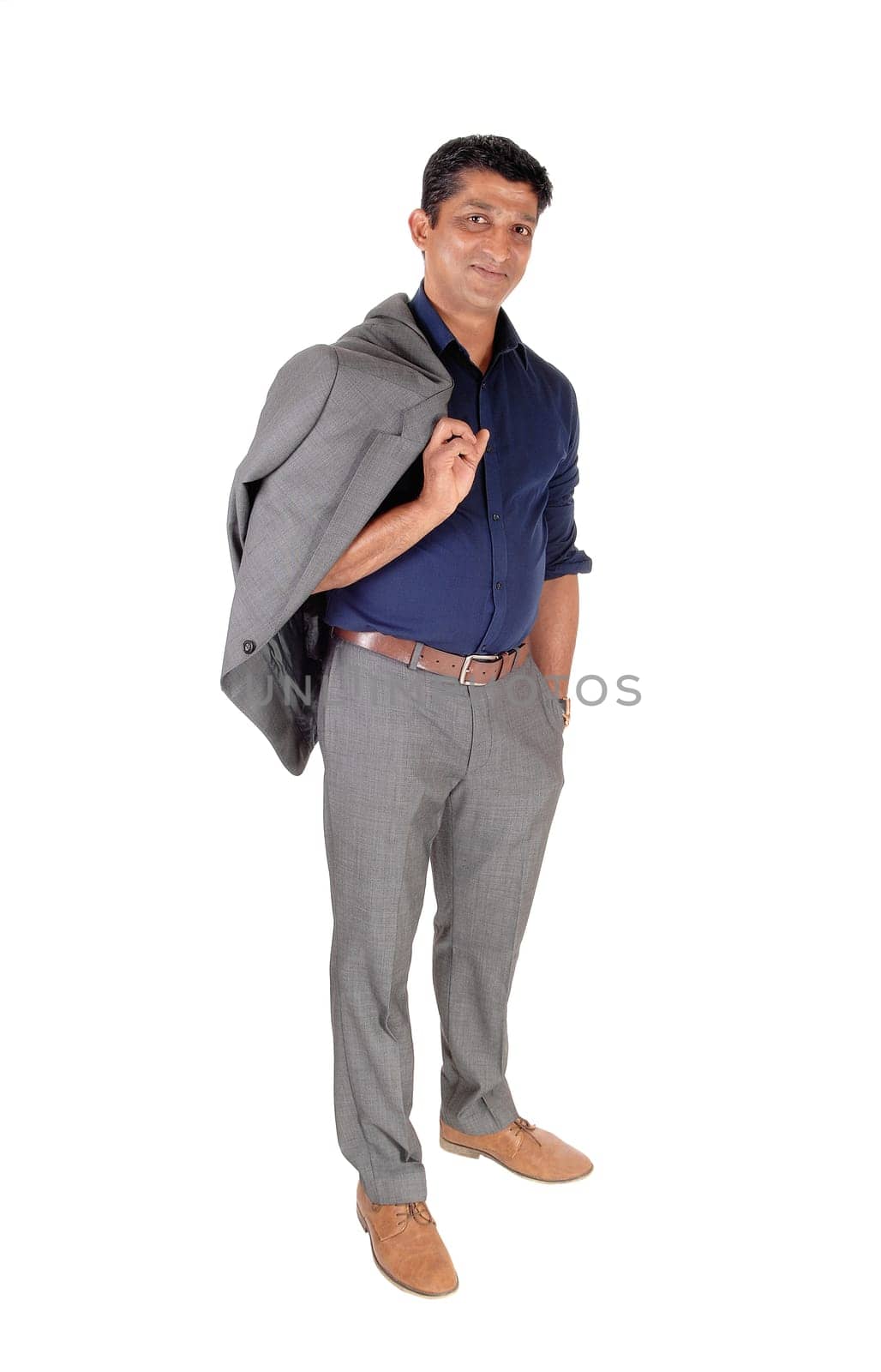A young East Indian business man standing in a gray suit with his jacket.over his shoulder, smiling, isolated for white background.