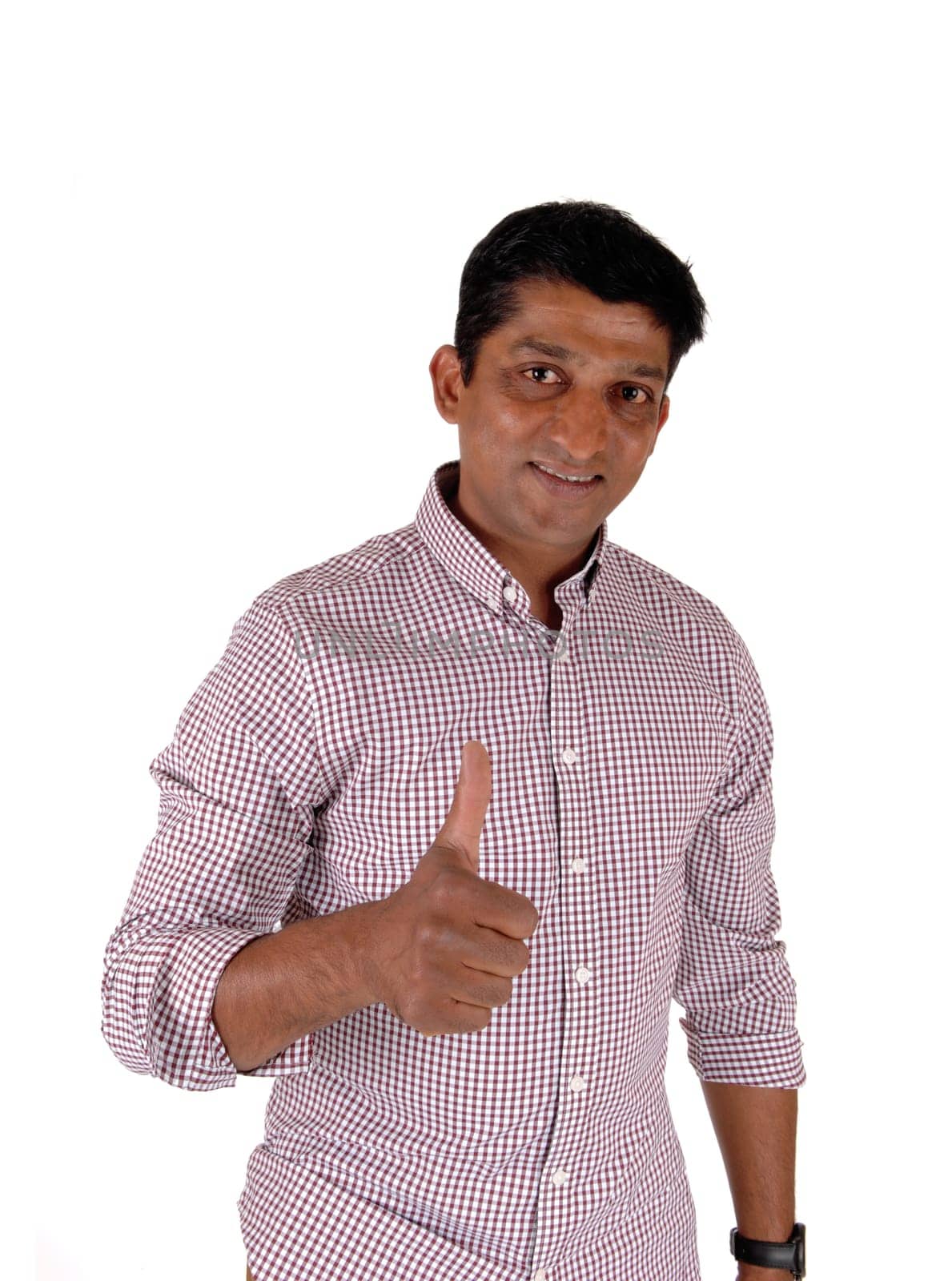 Happy looking man in a red checkered shirt standing and pointing with .his thump up, smiling, isolated for white background.