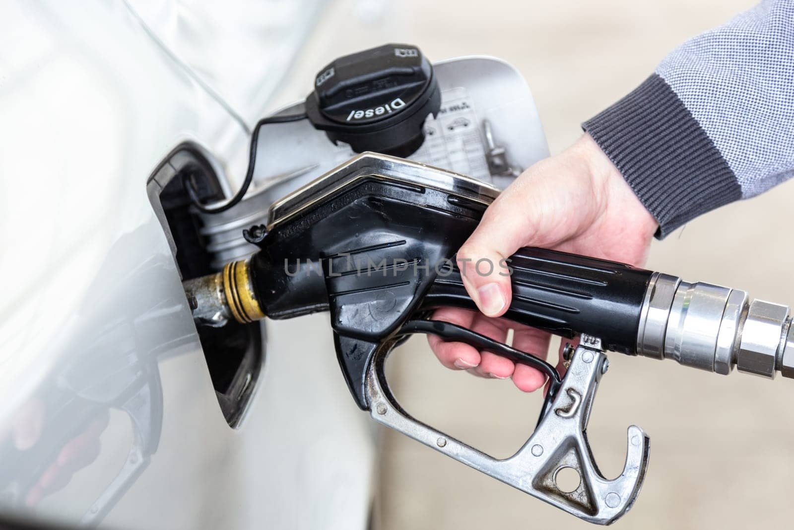 Pumping gas at gas pump. Closeup of man pumping gasoline fuel in car at gas station.