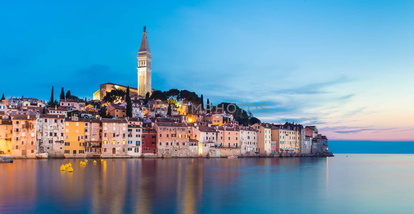Colorful sunset of Rovinj town, Croatian fishing port on the west coast of the Istrian peninsula. Colorful evening seascape of Adriatic Sea. Traveling concept.