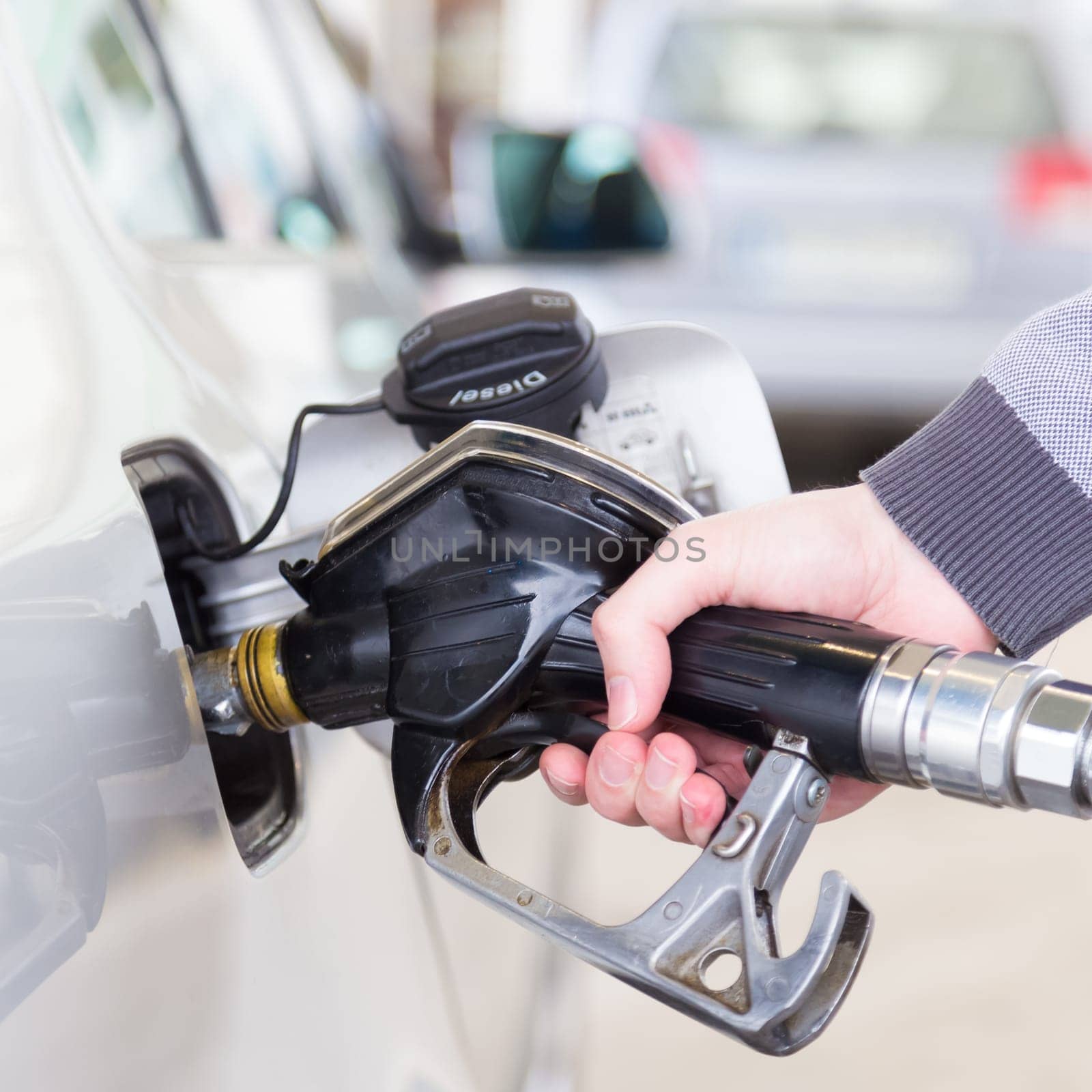 Pumping gas at gas pump. Closeup of man pumping gasoline fuel in car at gas station.