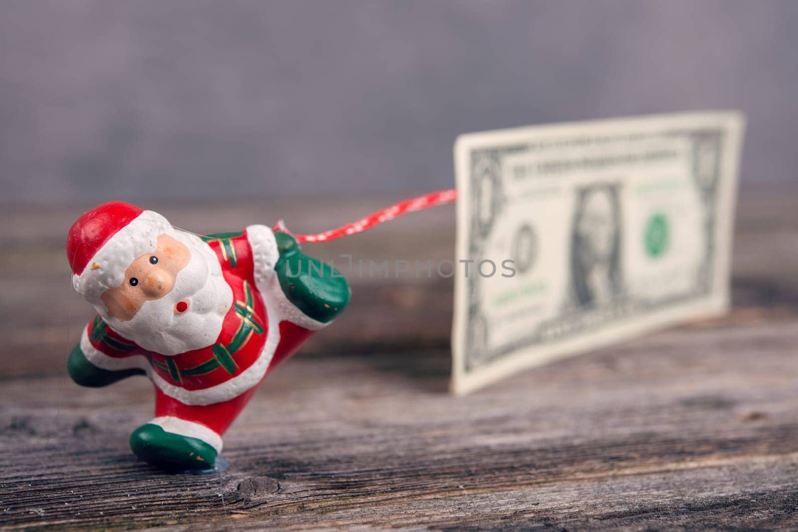 little Santa Claus pulling big euro banknote