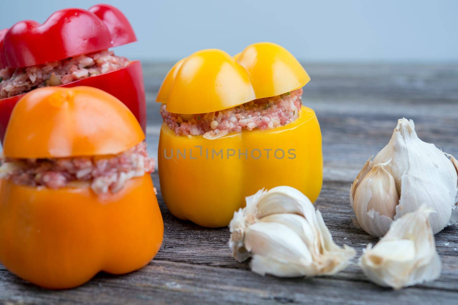 colorful filled pepper,garlic and onion on wooden ground