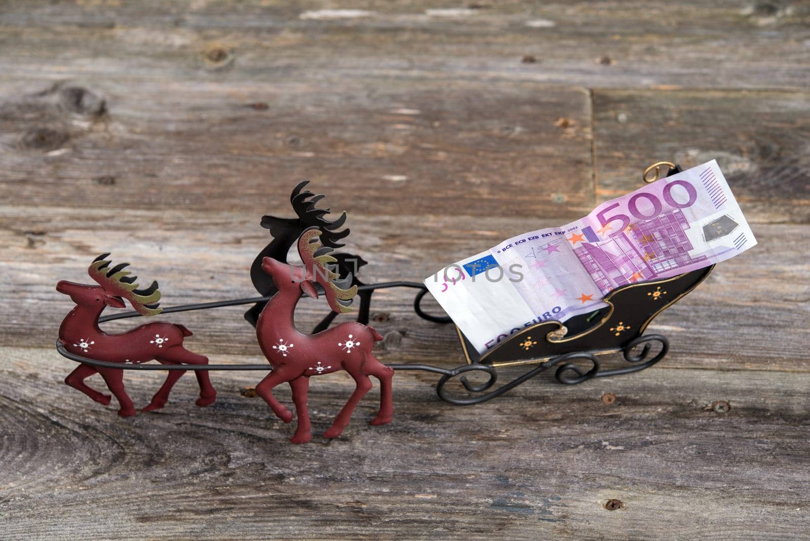 christmas sill with money in reindeer carriage , fir branch and candle