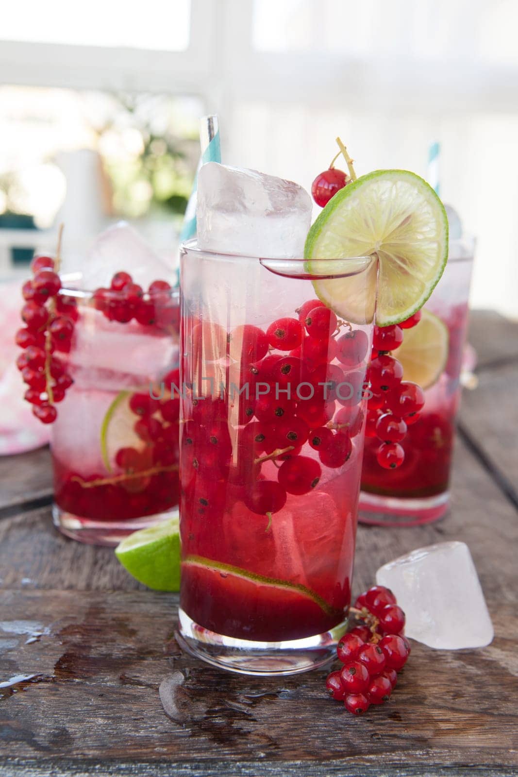 High glass with cocktail with fresh red currants and lime