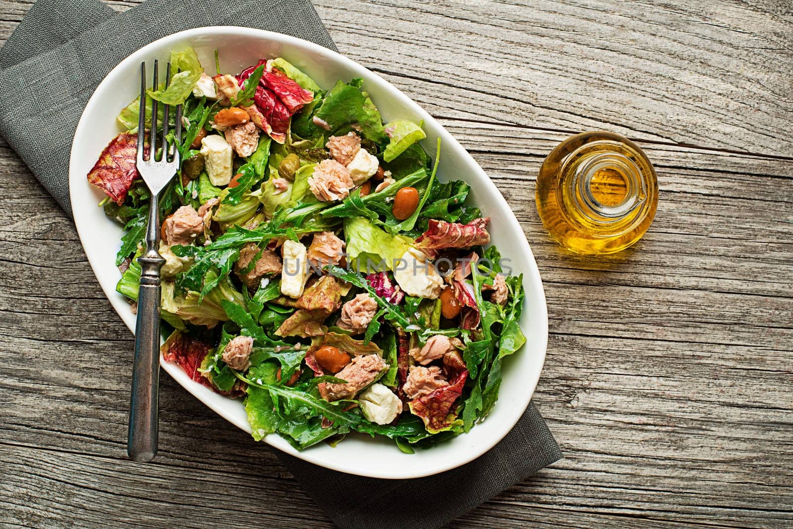 Tuna salad with lettuce beans and cheese on wooden table
