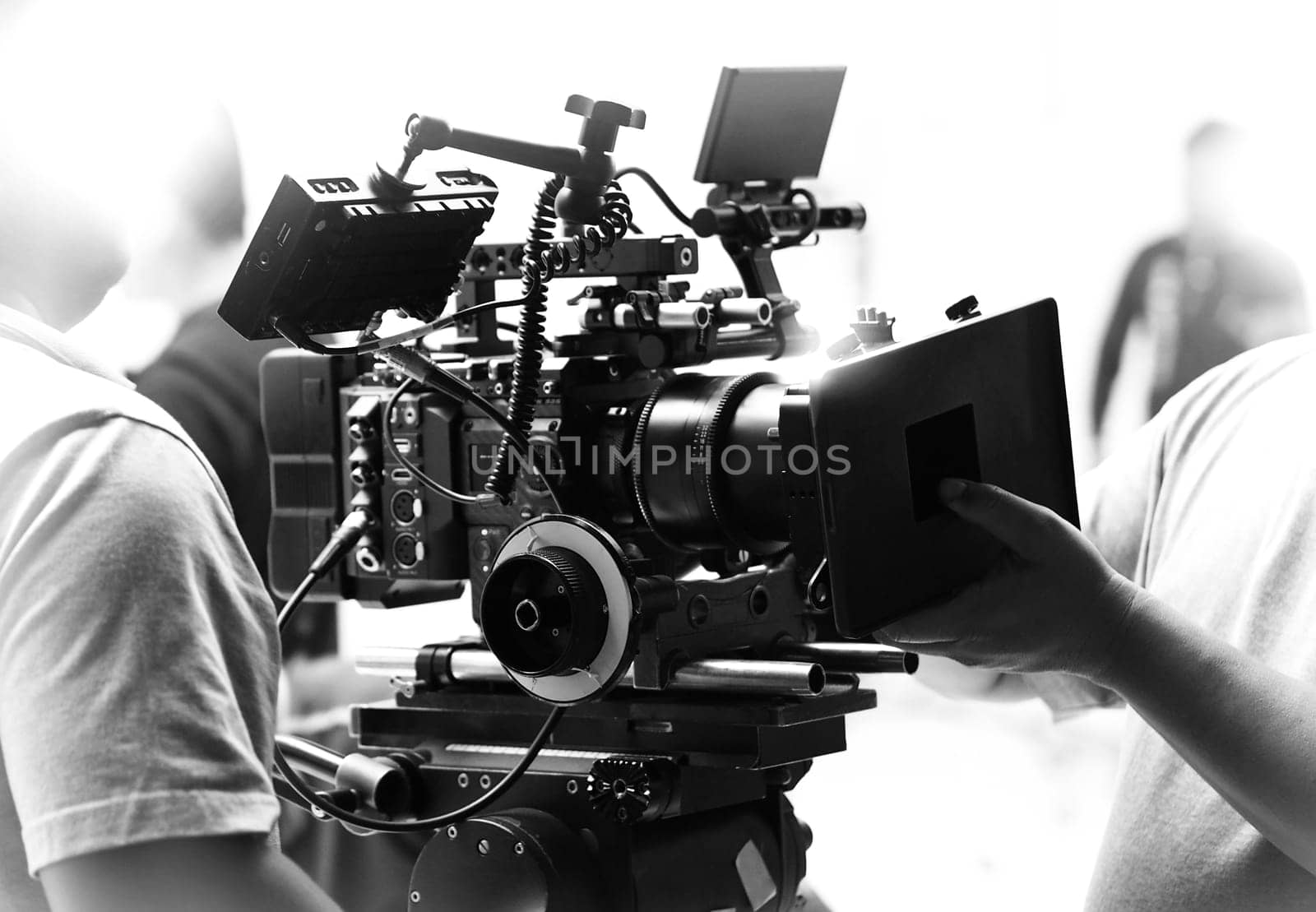 Movie shooting or video filming production by crew team and professional equipment such as super ultra high definition digital camera with tripod and lighting set in studio and black and white styles.