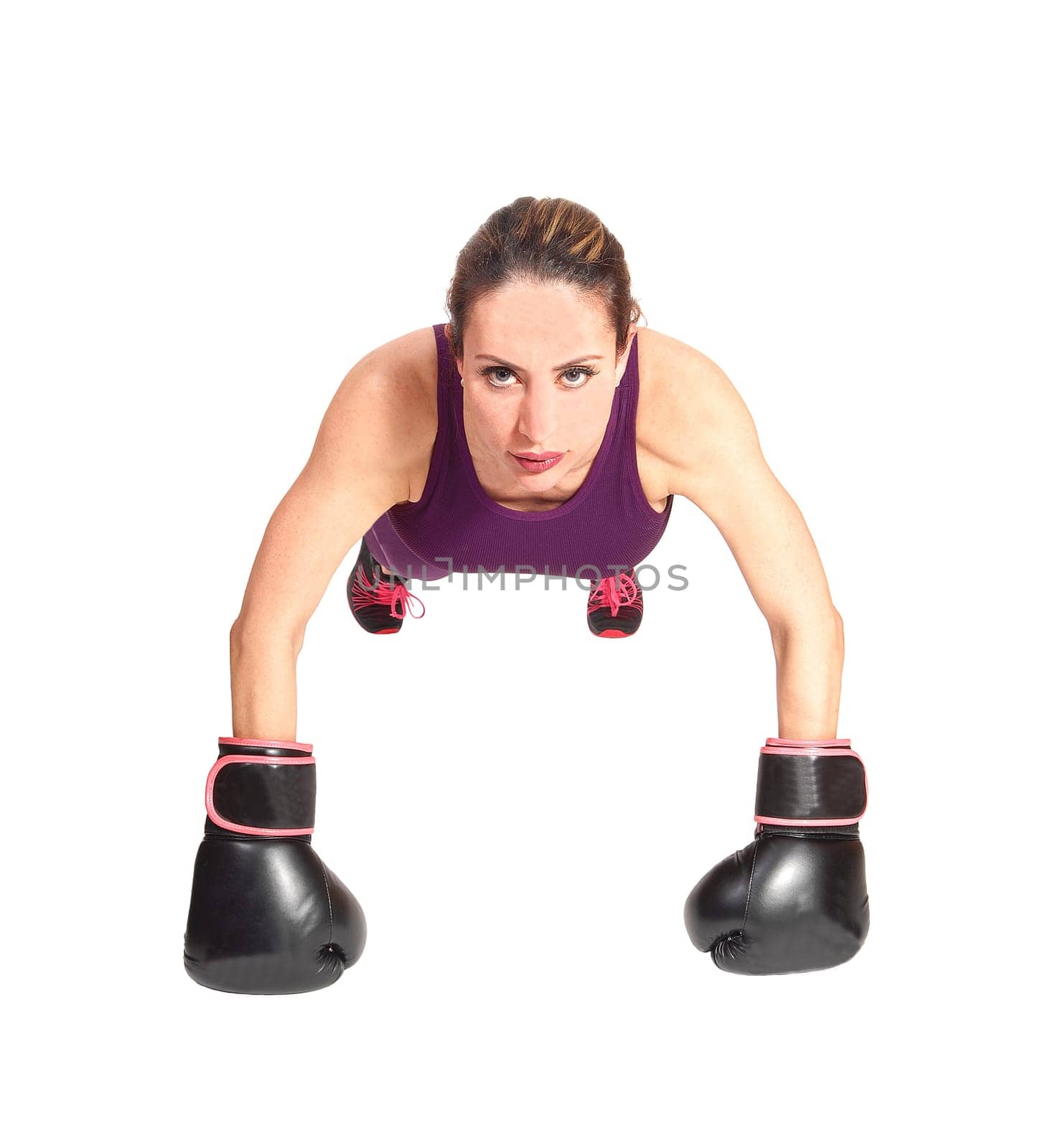 A pretty brunette woman with black boxing gloves doing some punch-ups.in the floor, isolated for white background.