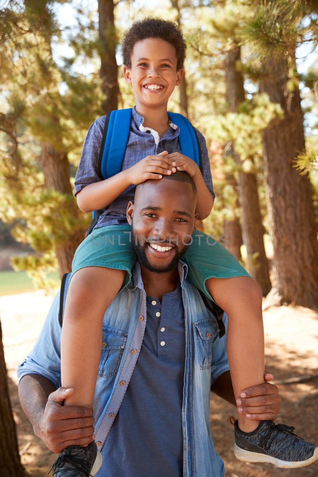 Portrait Of Father Walking In Woods Carrying Son On Shoulders